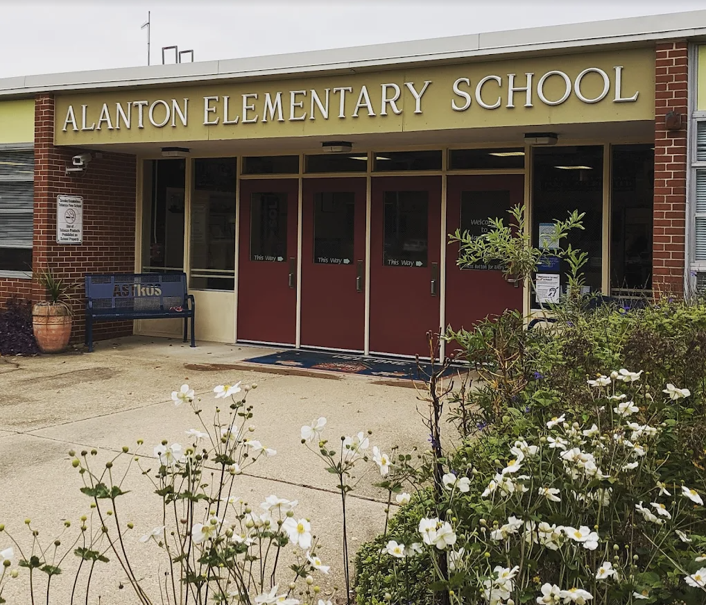 Front entrance of Alanton Elementary School with flowers and plants outside.