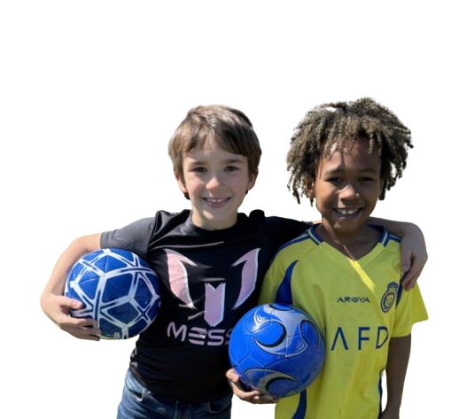Two young boys standing together, each holding a blue and white soccer ball, smiling at the camera. One boy is wearing a black Messi T-shirt and the other is wearing a yellow AFD football jersey.