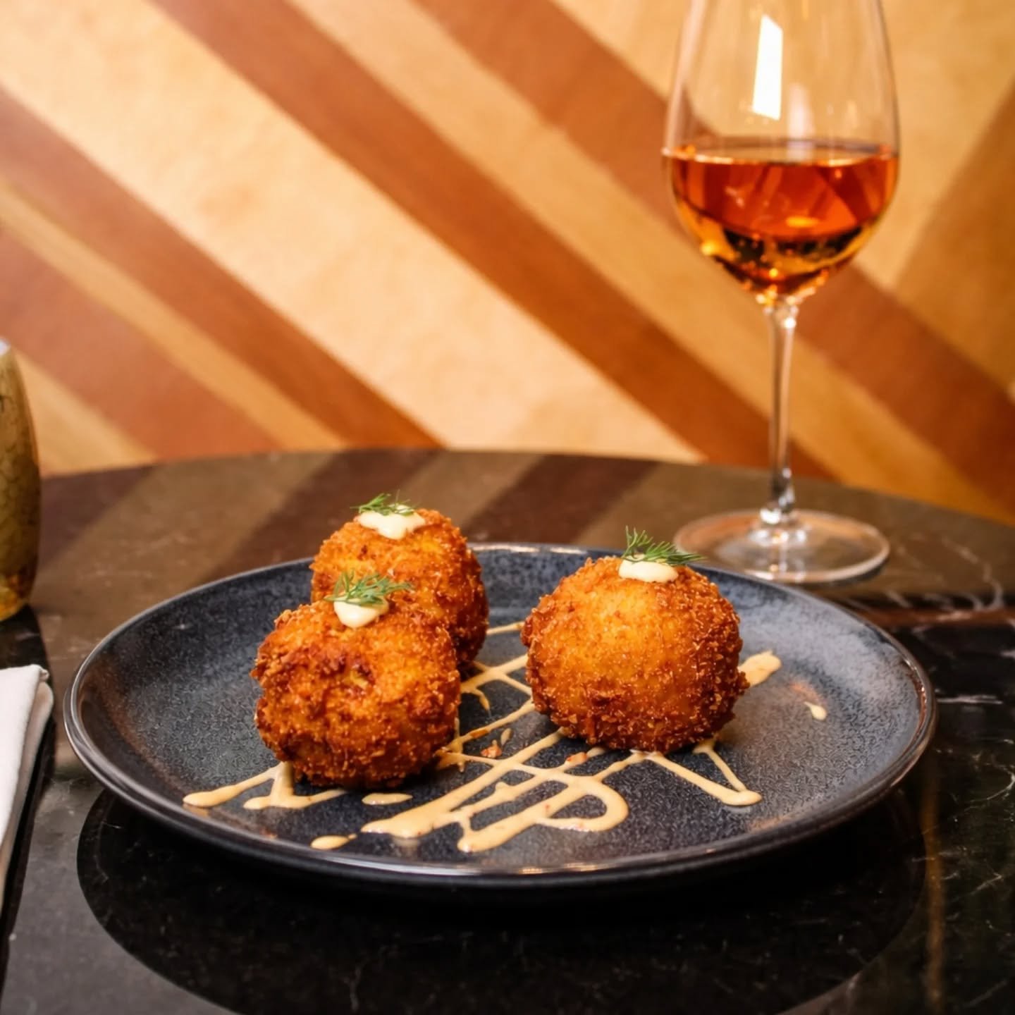 Our Saffron Paella Arancini -

Filled with salmon, spicy andouille, and aged manchego. Fried until perfectly crunchy, finished with a touch of sambal aioli. 

Rich, savory, a little smoky.... And even better with a glass of crisp ros&eacute; in hand!