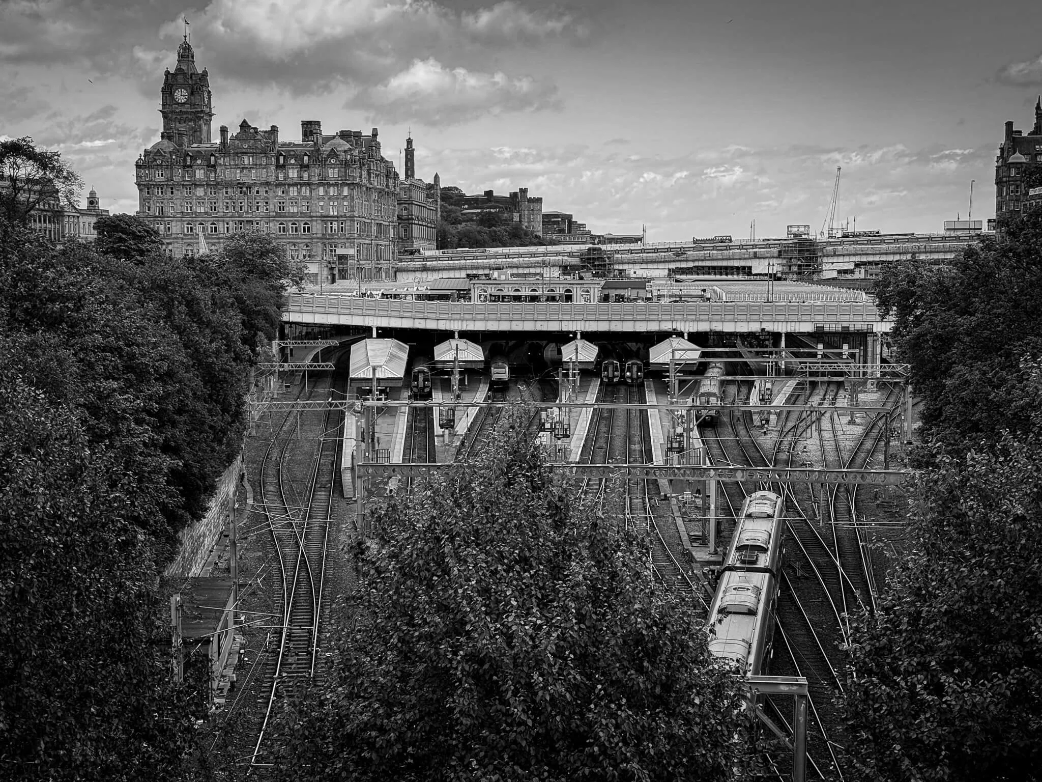 Black and white photo of Waverley station and train tracks in Edinburgh including The Balmoral Hotel