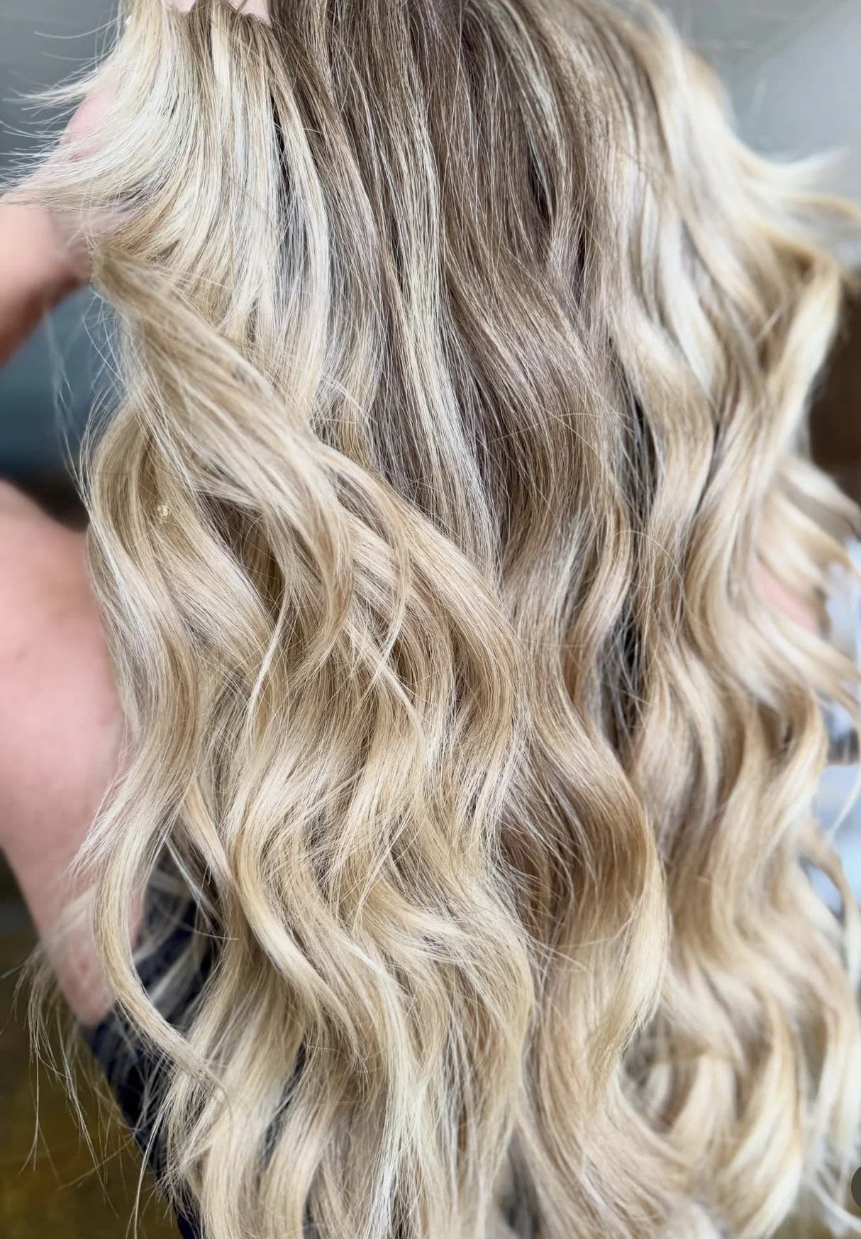 Close-up of blonde curly hair with highlights.