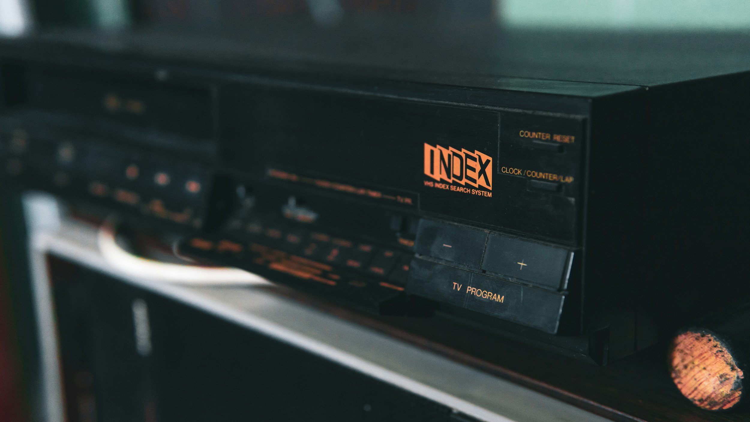 Close-up of vintage black VHS index search system with orange text labeling it and various buttons and controls.