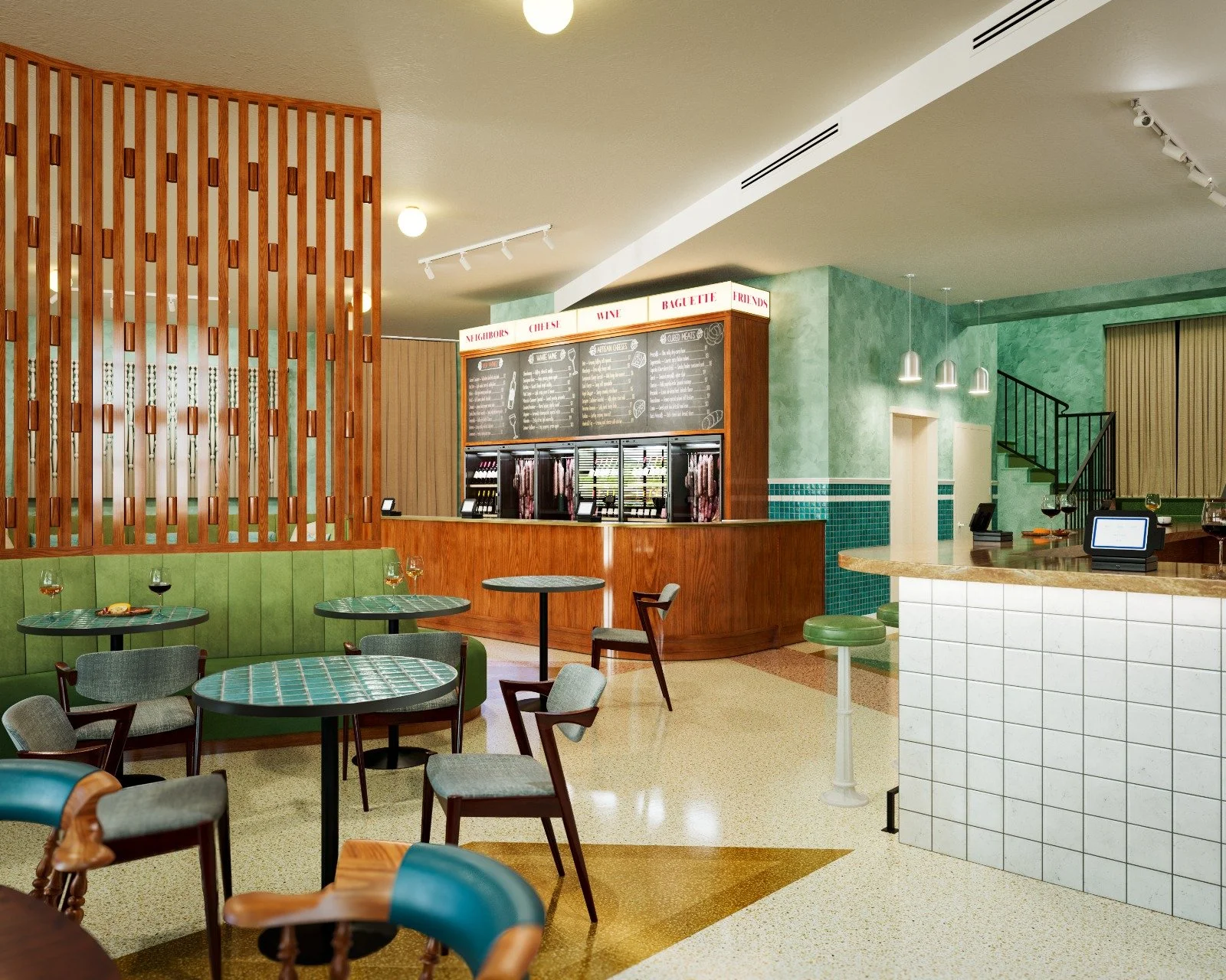 Interior of a cafe with green walls, wooden accents, and tiled counters. Green upholstered bench seating with tables and chairs, some with drinks. A chalkboard menu hangs behind the counter, and modern lighting fixtures are on the ceiling. A staircas