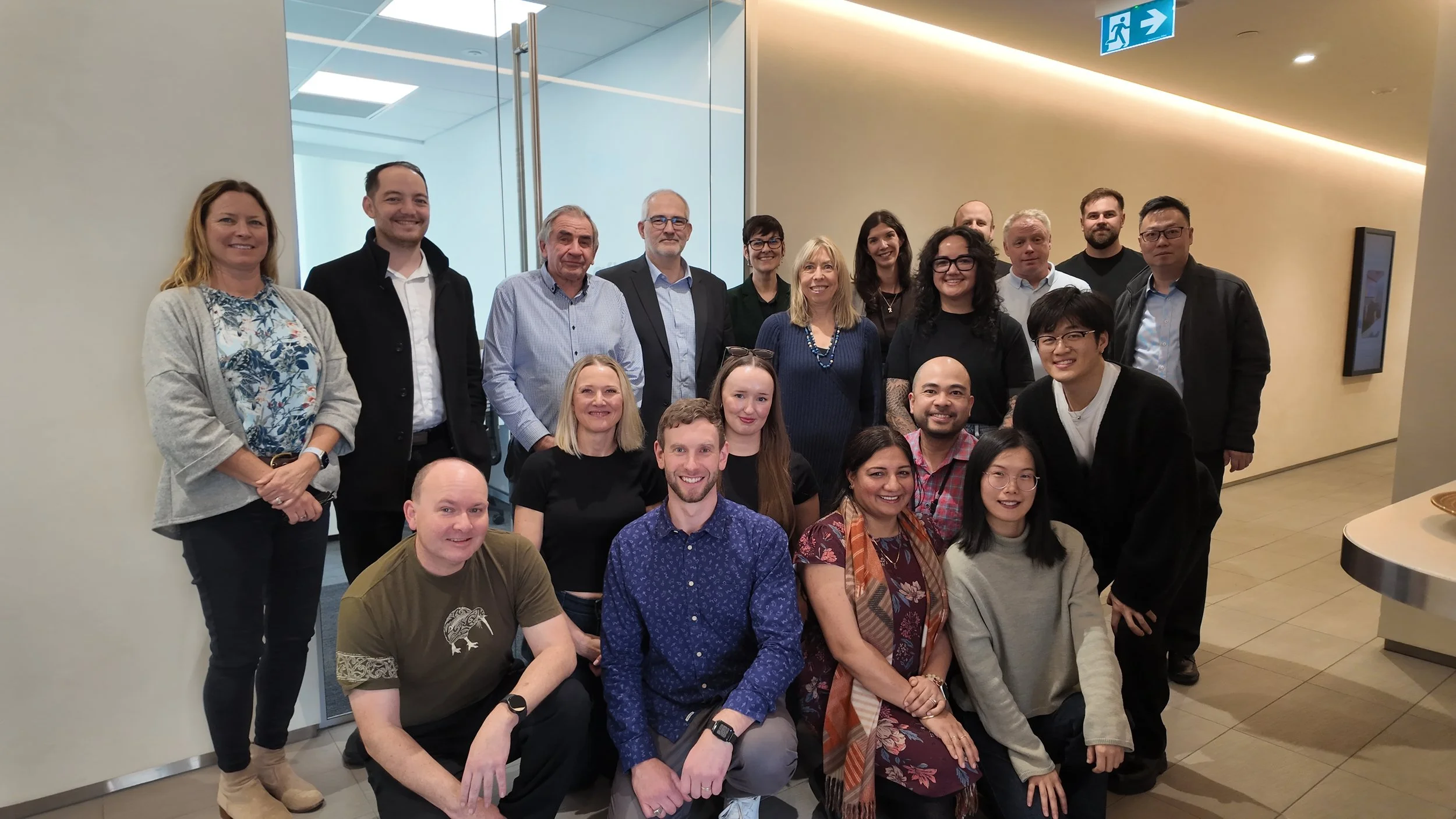 Hampton jones team standing and sitting in an indoor office or conference area, smiling at the camera.