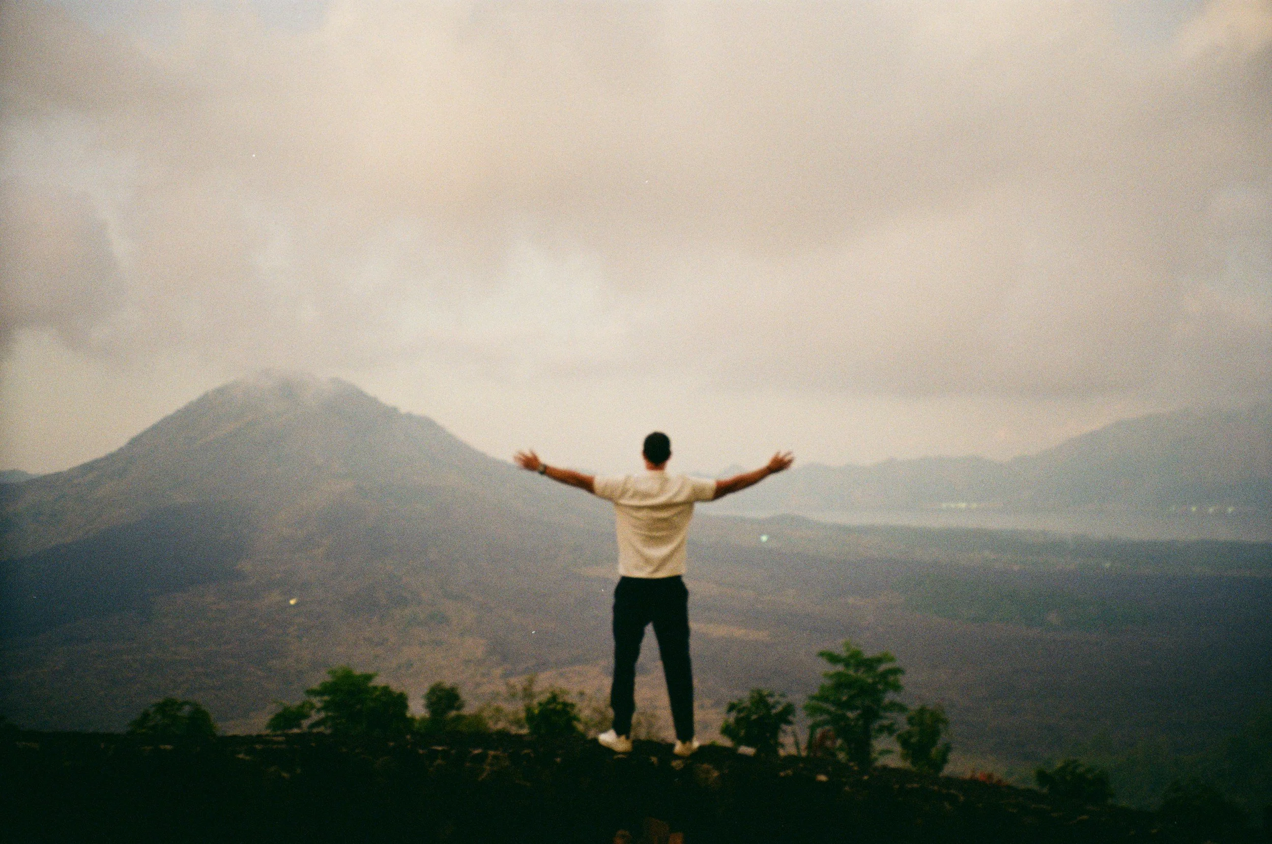 Person with arms outstretched on a Colorado mountaintop, representing healing and recovery from trauma and PTSD.