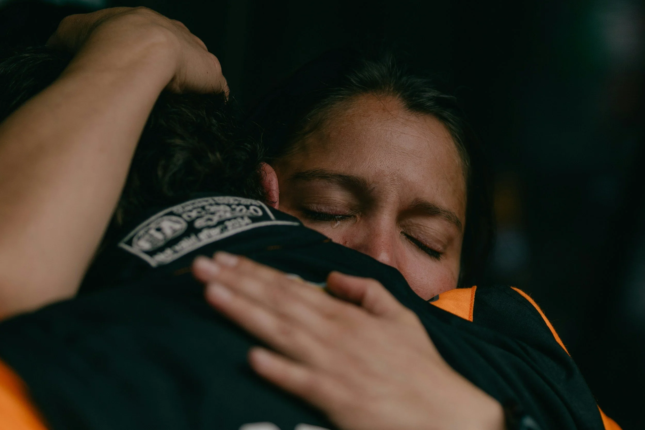 Two first responders embracing with eyes closed, showing the comfort and support that first responder therapy in Evergreen, Colorado, can offer.