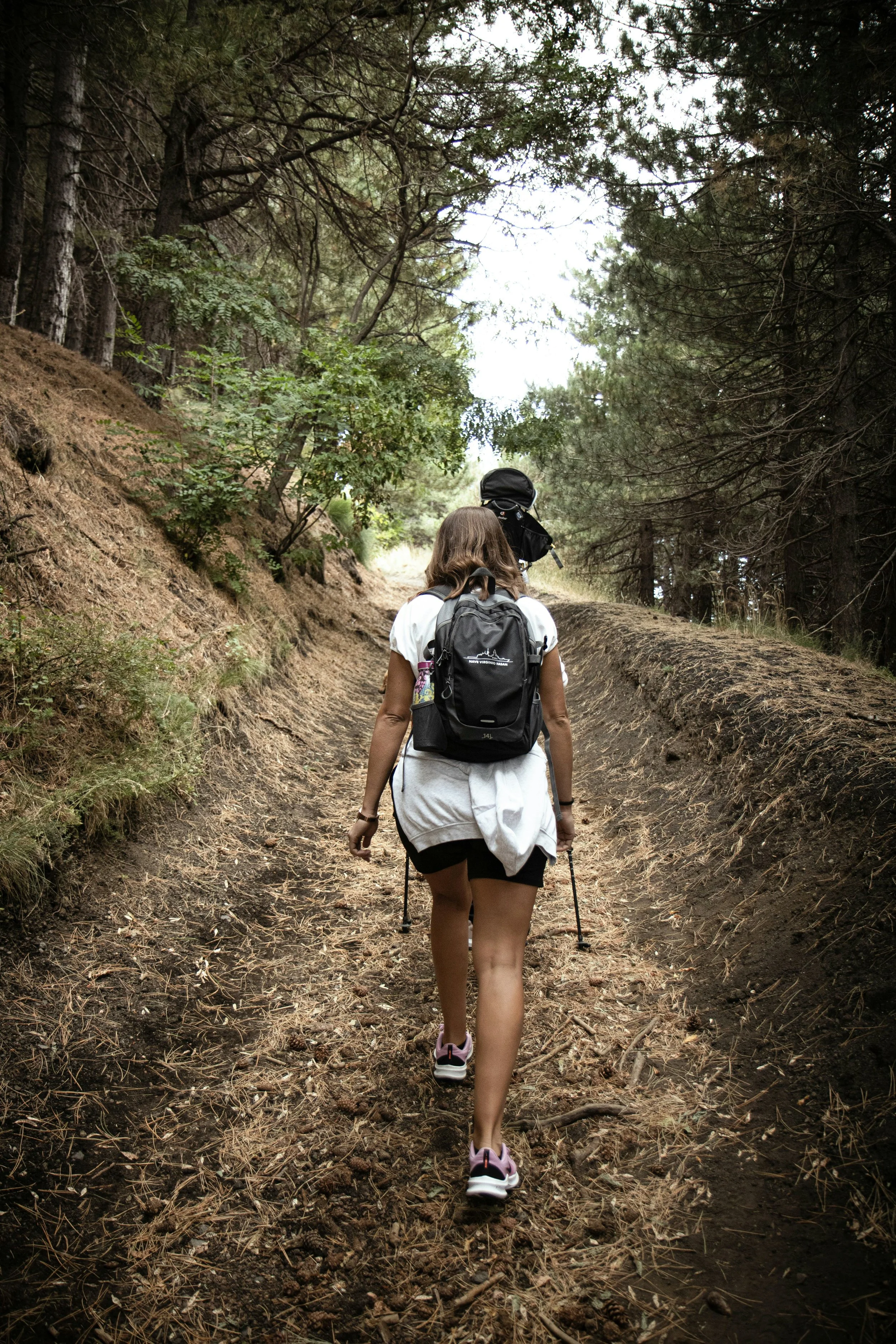 young woman on a casual hike through some trees
