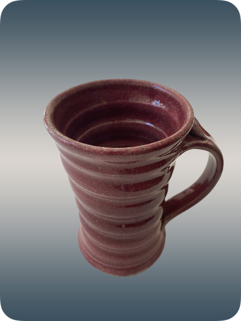 A ceramic mug with a reddish-brown striped pattern on a gradient background.