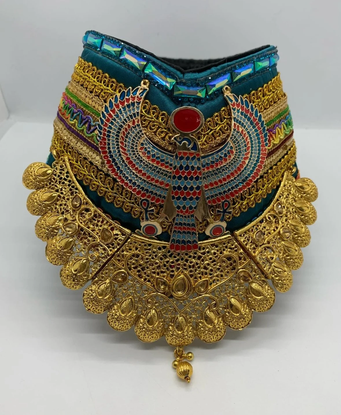 Jewelry set with a large, colorful peacock pendant, gold filigree necklace, and multiple layered bracelets with blue, green, purple, and gold details.