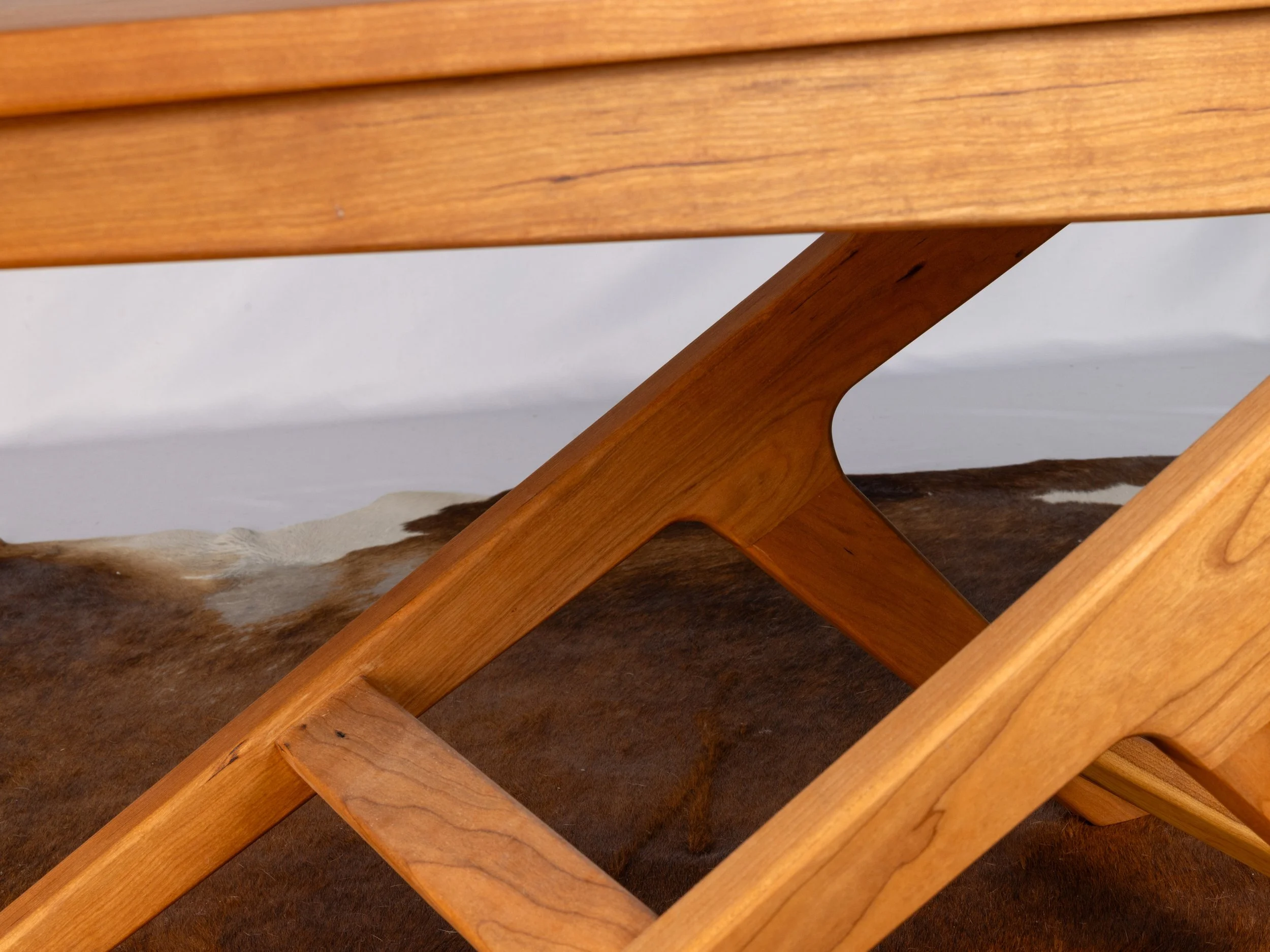 Close-up of wooden furniture leg and cross-support.