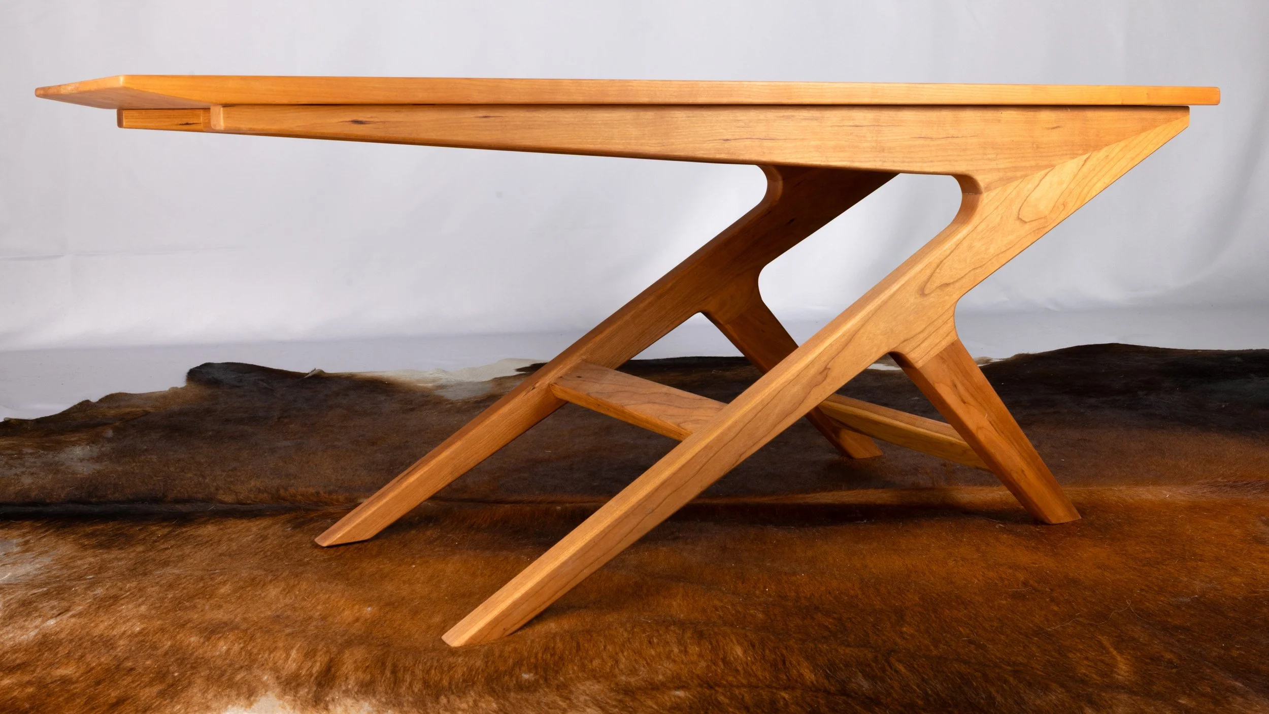 A wooden table with a modern, angular design.