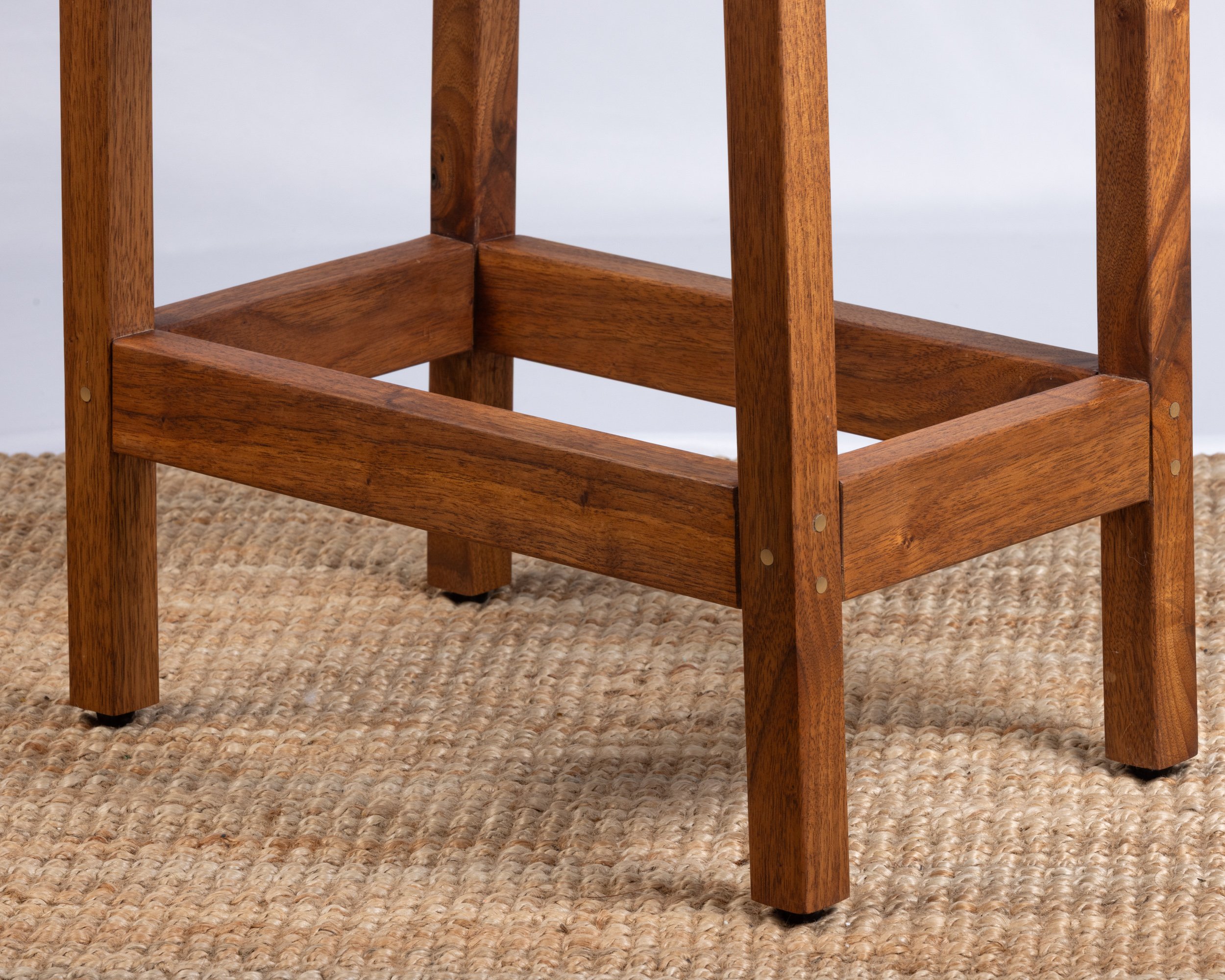 Close-up of a wooden table leg and shelf frame.