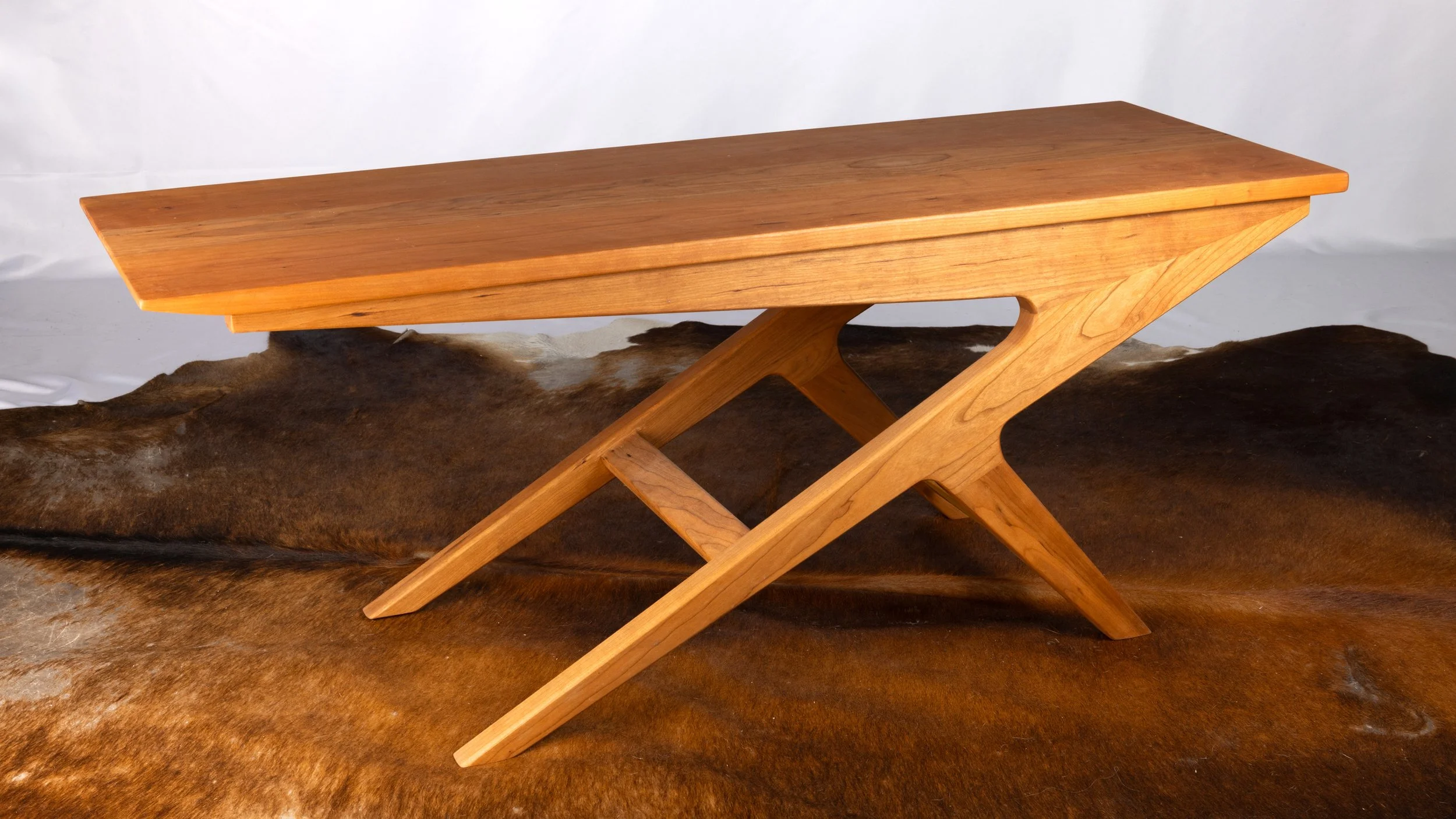 A wooden table with a mid-century modern design.