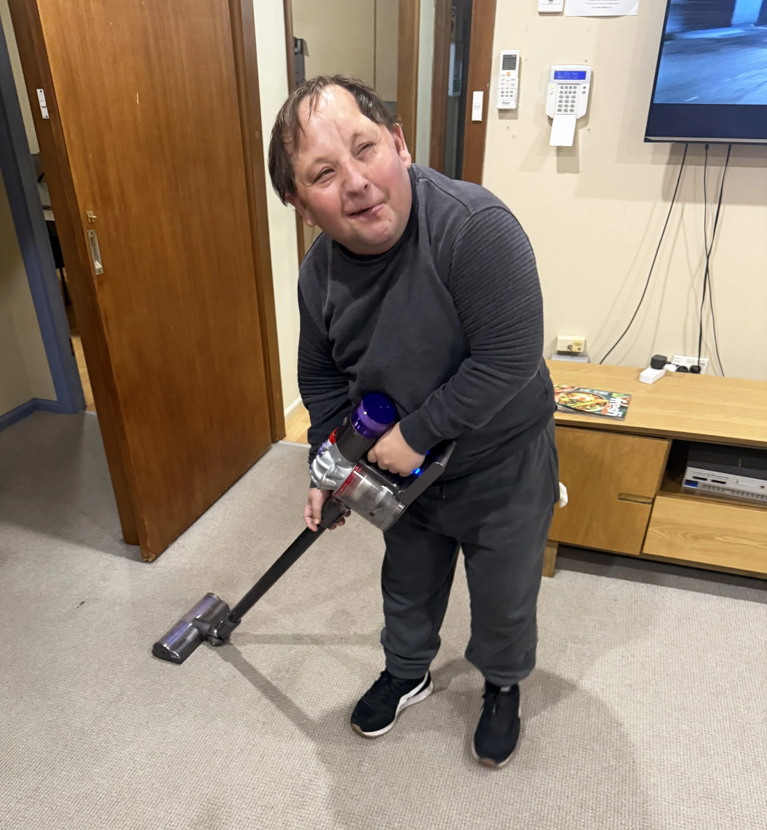 A male participant using a hand held vacuum