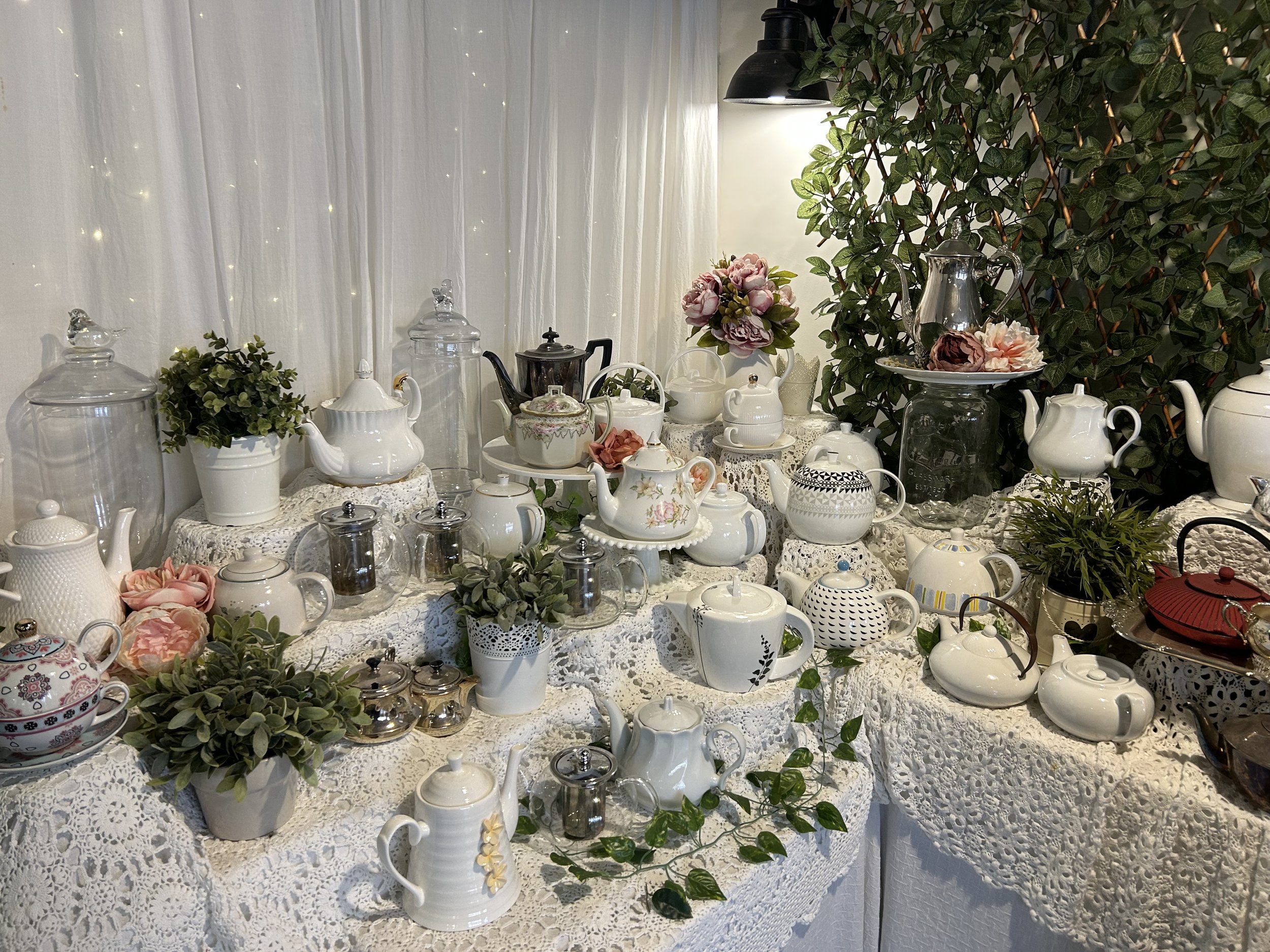A wide variety of tea pots and flowers on display