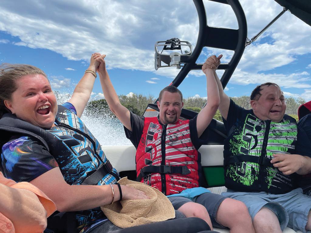 Participants with their arms in the air on a boat