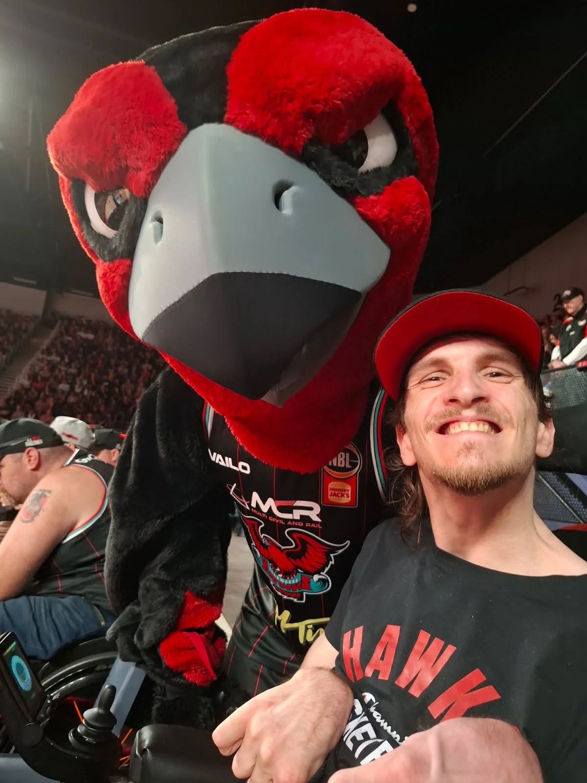 Man in wheelchair with the mascot of Illawarra Hawks