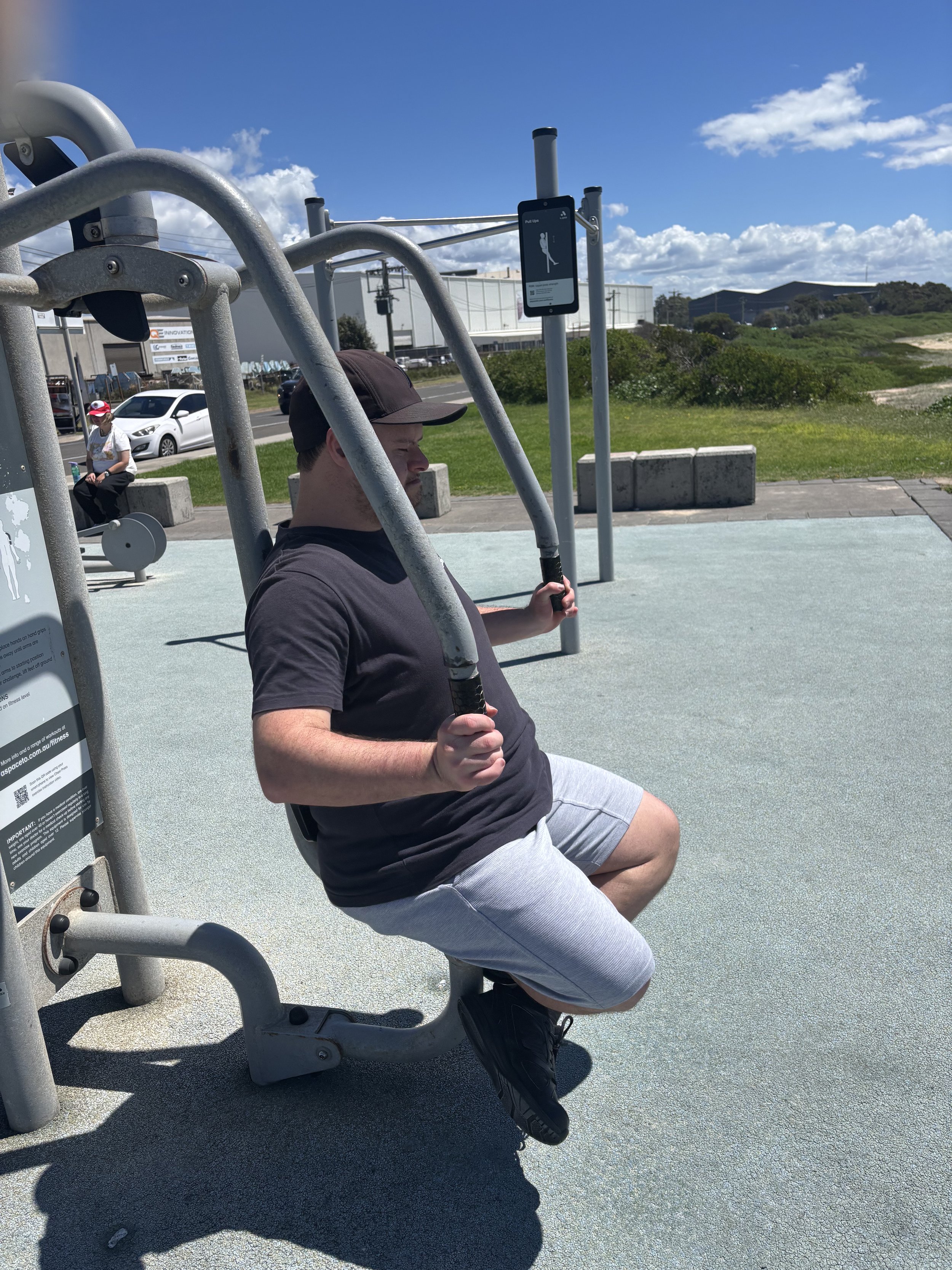 Participant at outdoor exercise equipment on a sunny day