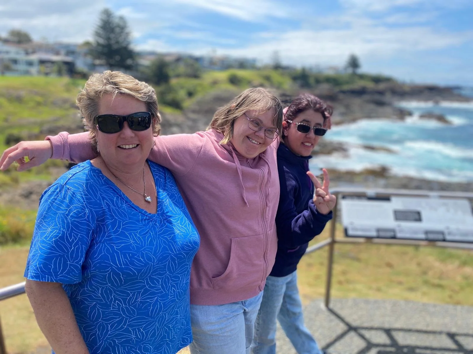 A Support Worker and participants smiling at a lookout