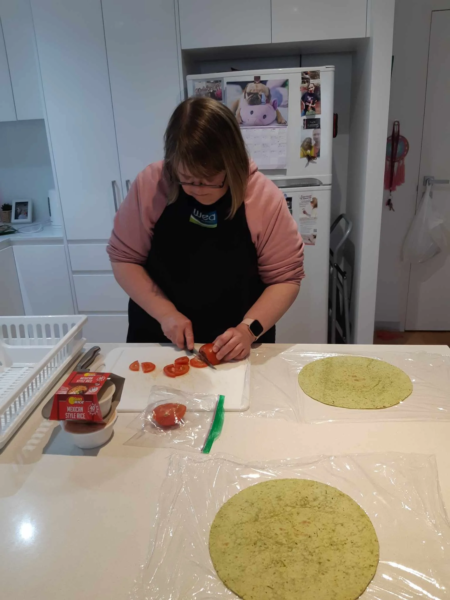 Woman cutting up a tomato to make a salad wrap