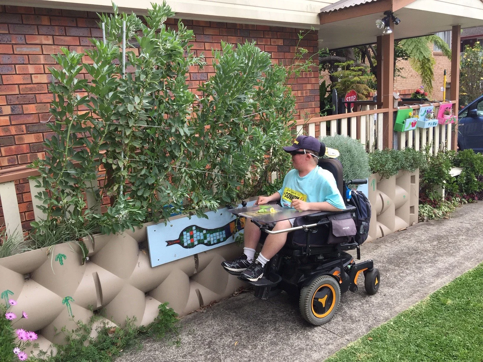 Participant in a power chair doing work in the garden