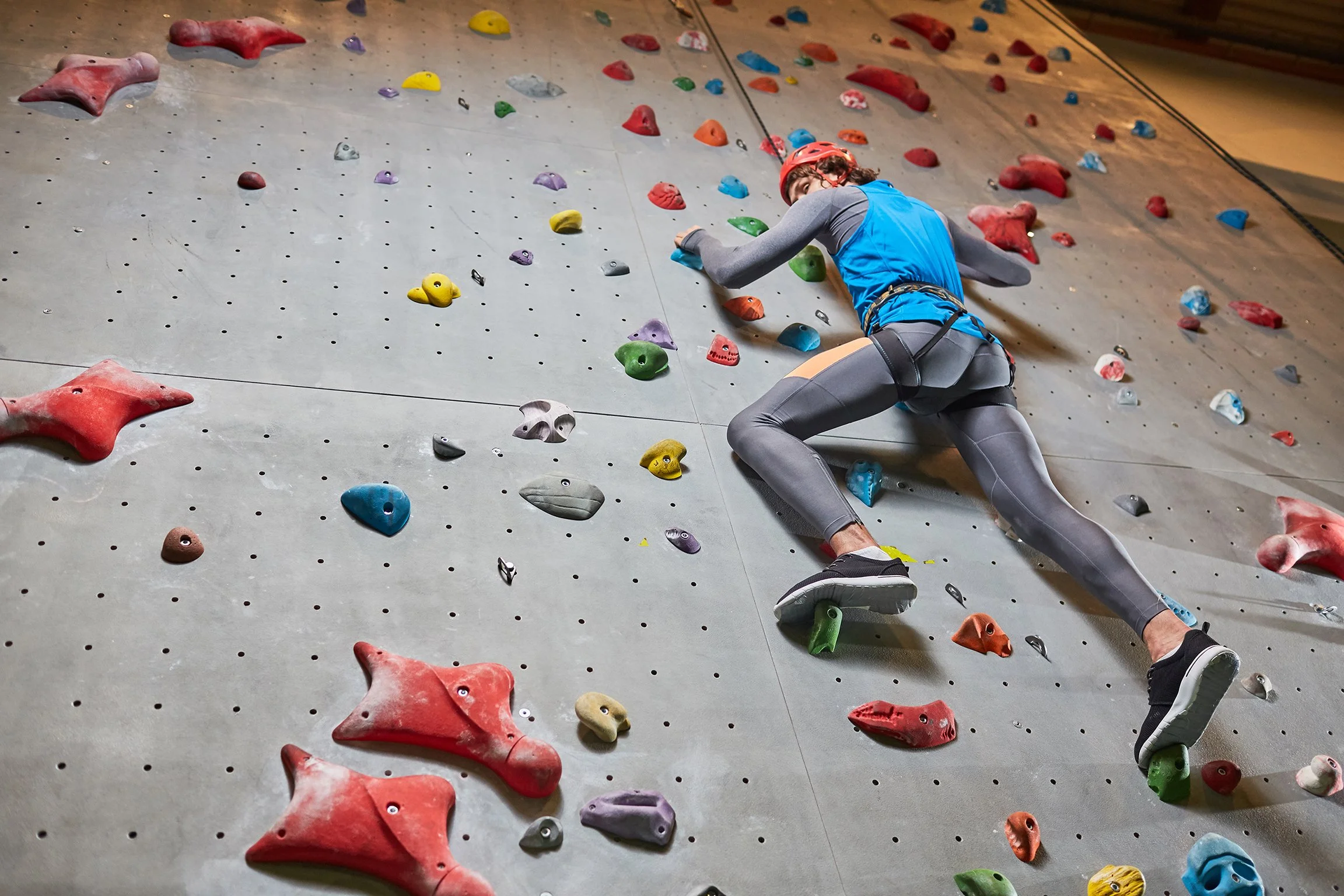 Young man on a wall at indoor rock climbing 