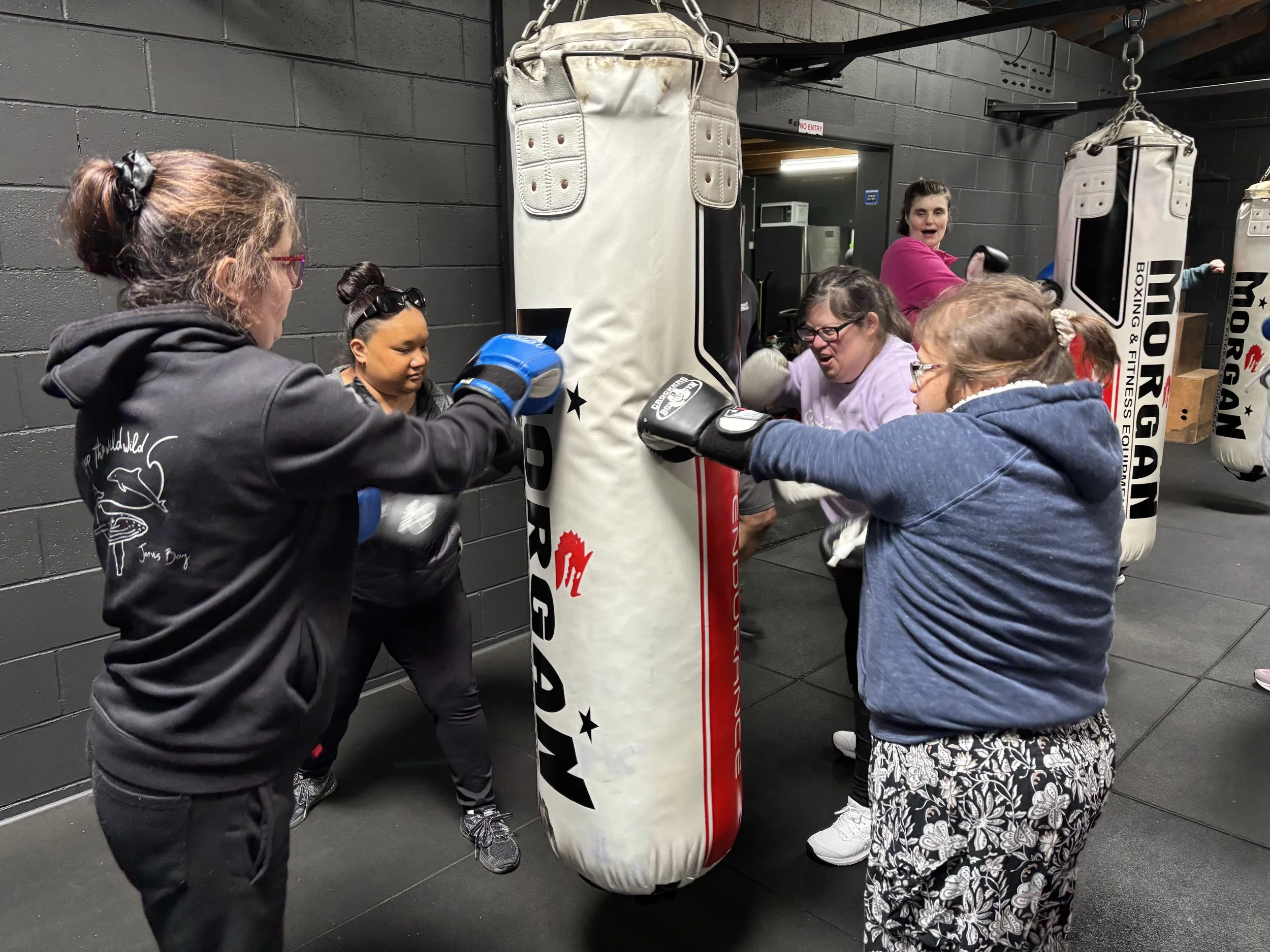 A group of women punching the punching bag