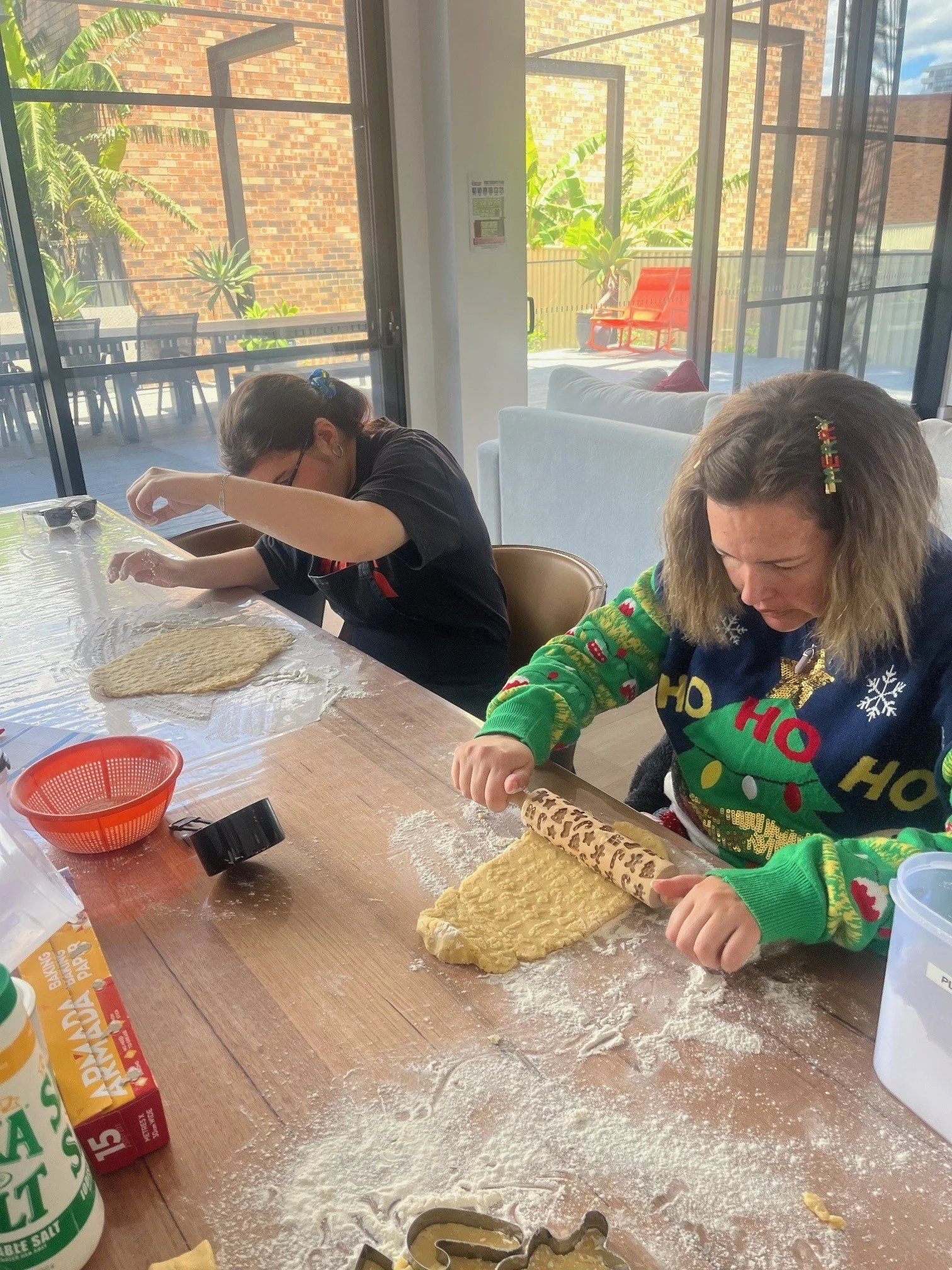 Two participants rolling out pastry on a table