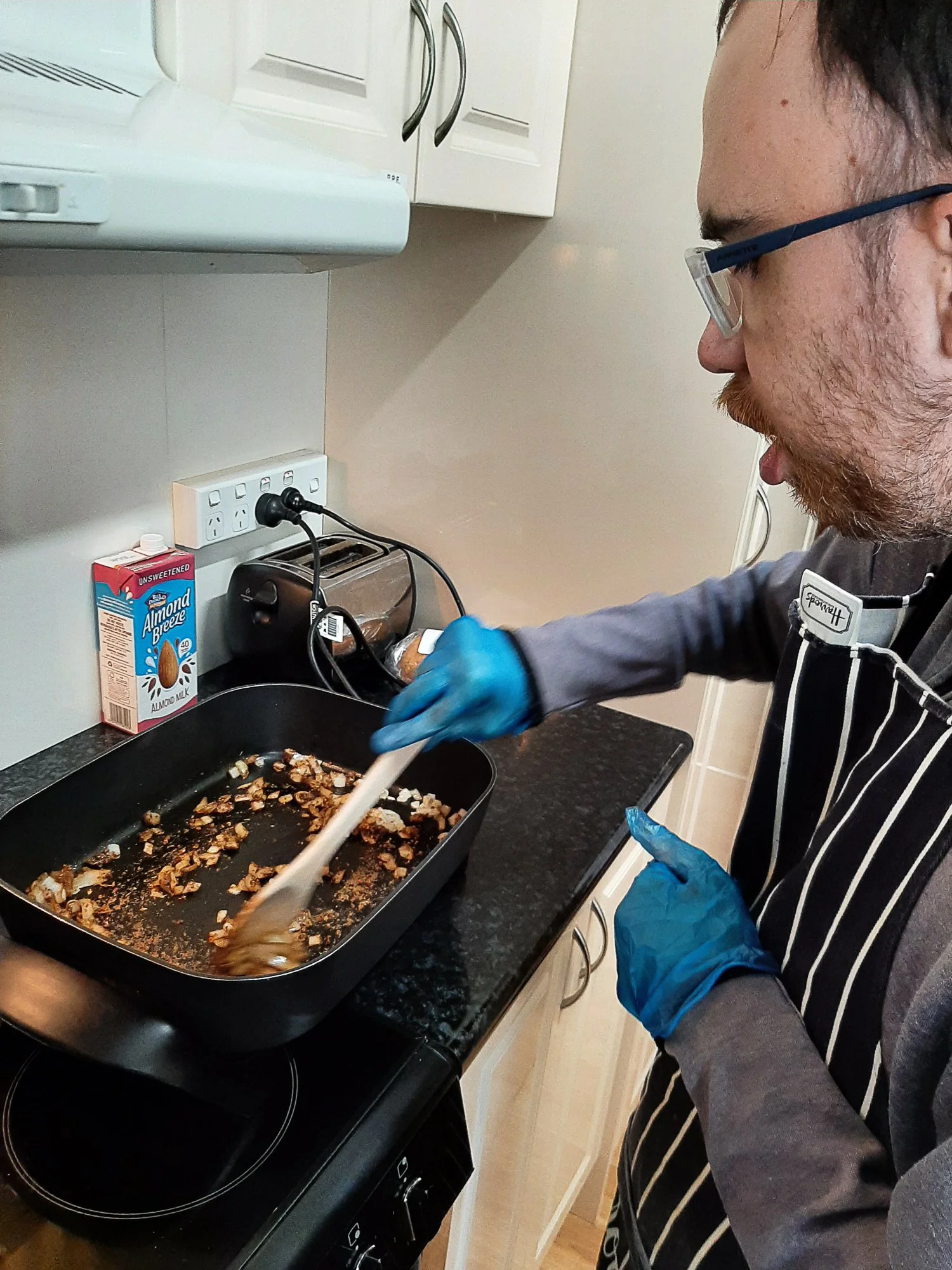 A male participant stirring onions in a frying pan