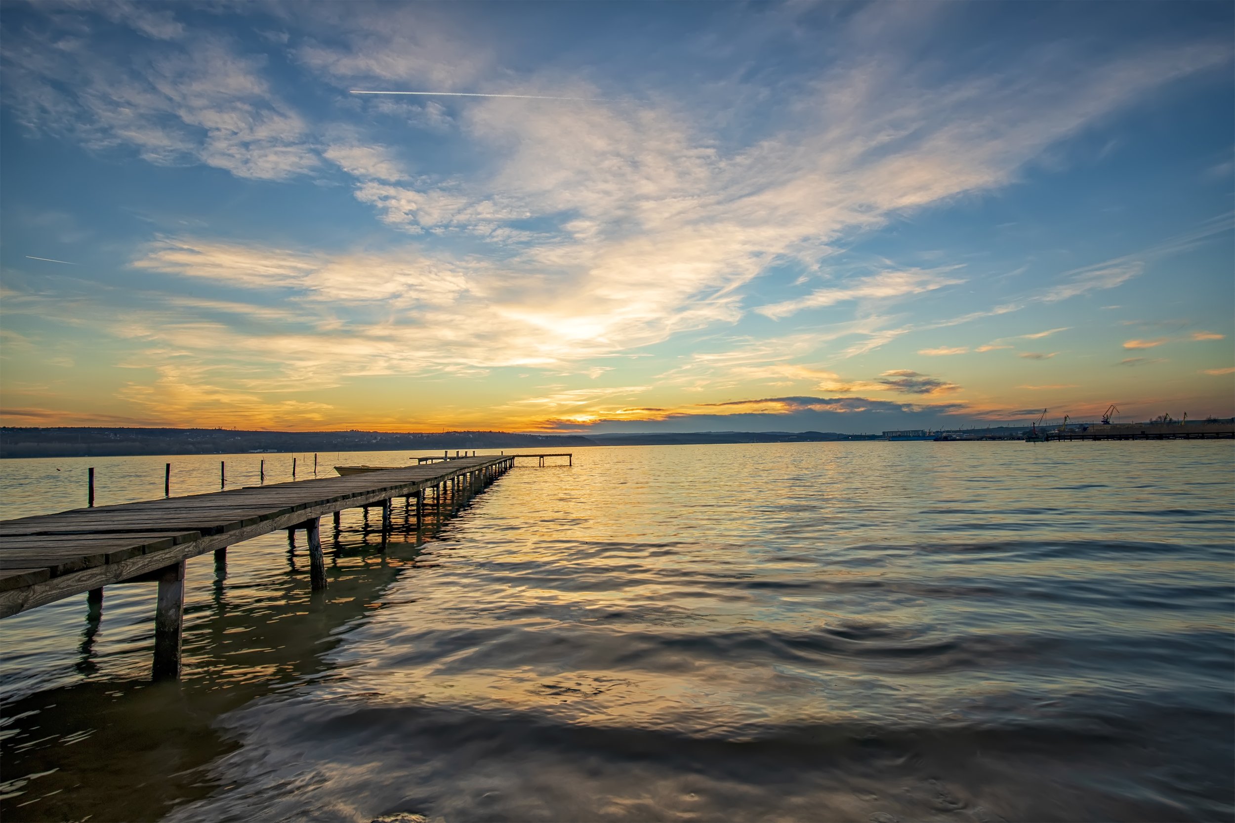 A photo of the sun setting over a jetty at a Lake Illawarra