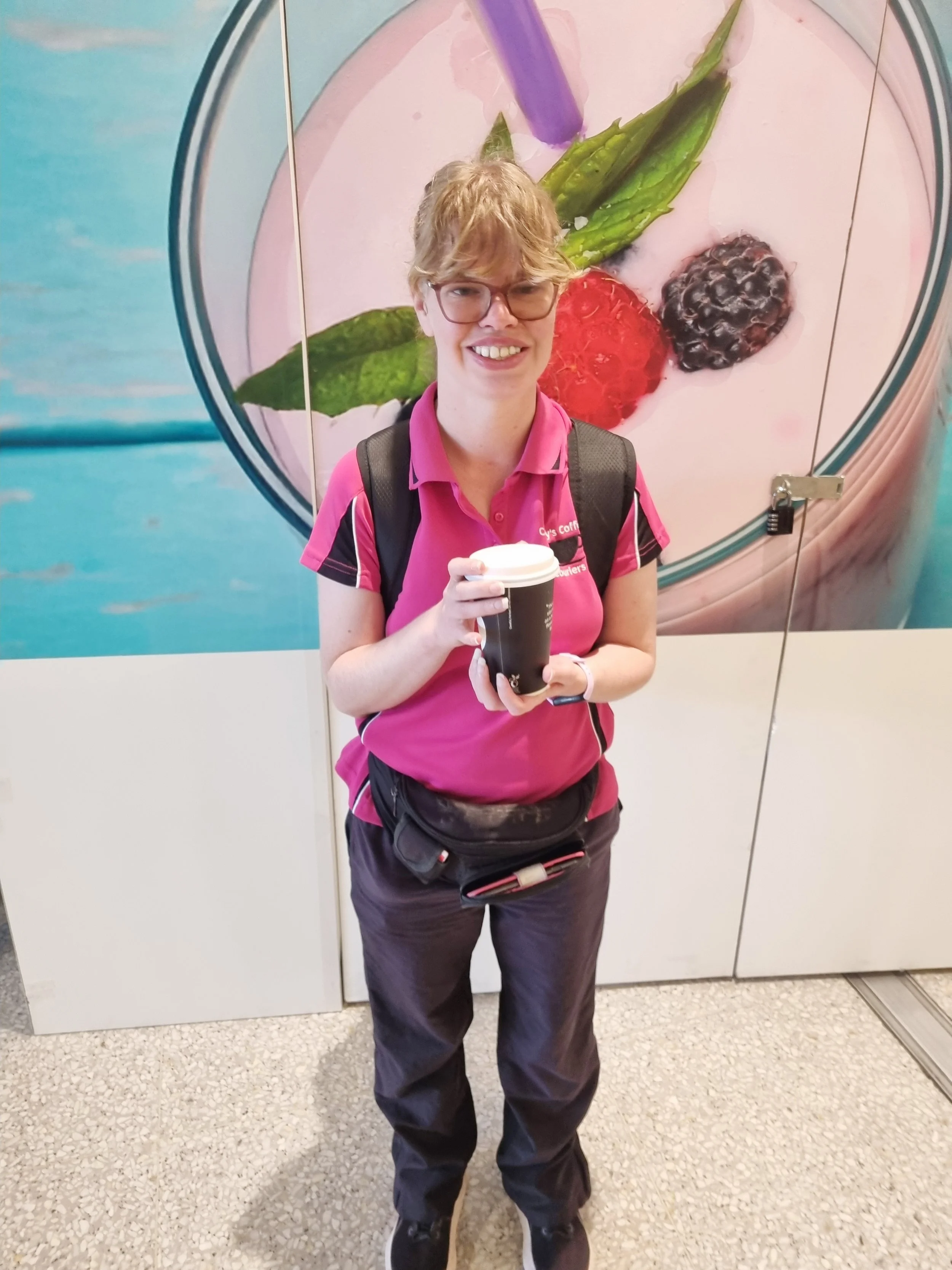 Carly holding a take away coffee cup