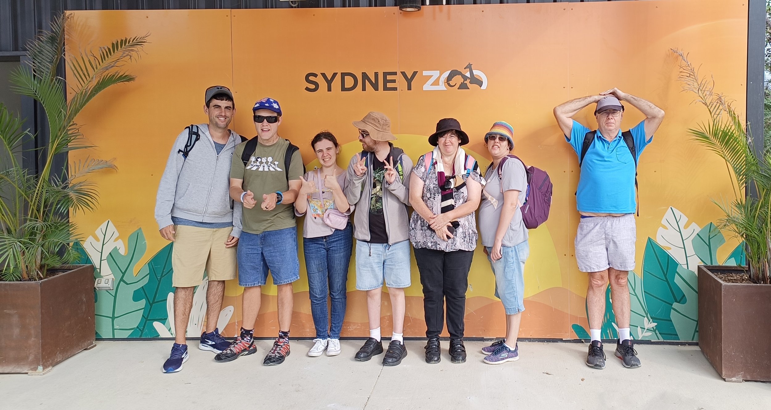 A group of participants under a Sydney Zoo sign