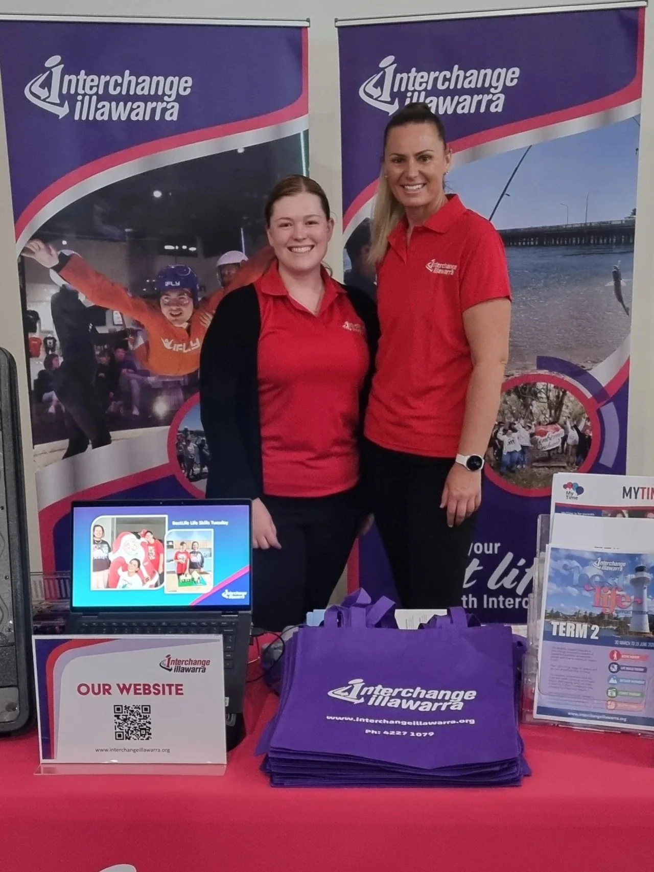 Jess and Cat standing in front of Interchange banners at IDO Expo 2026