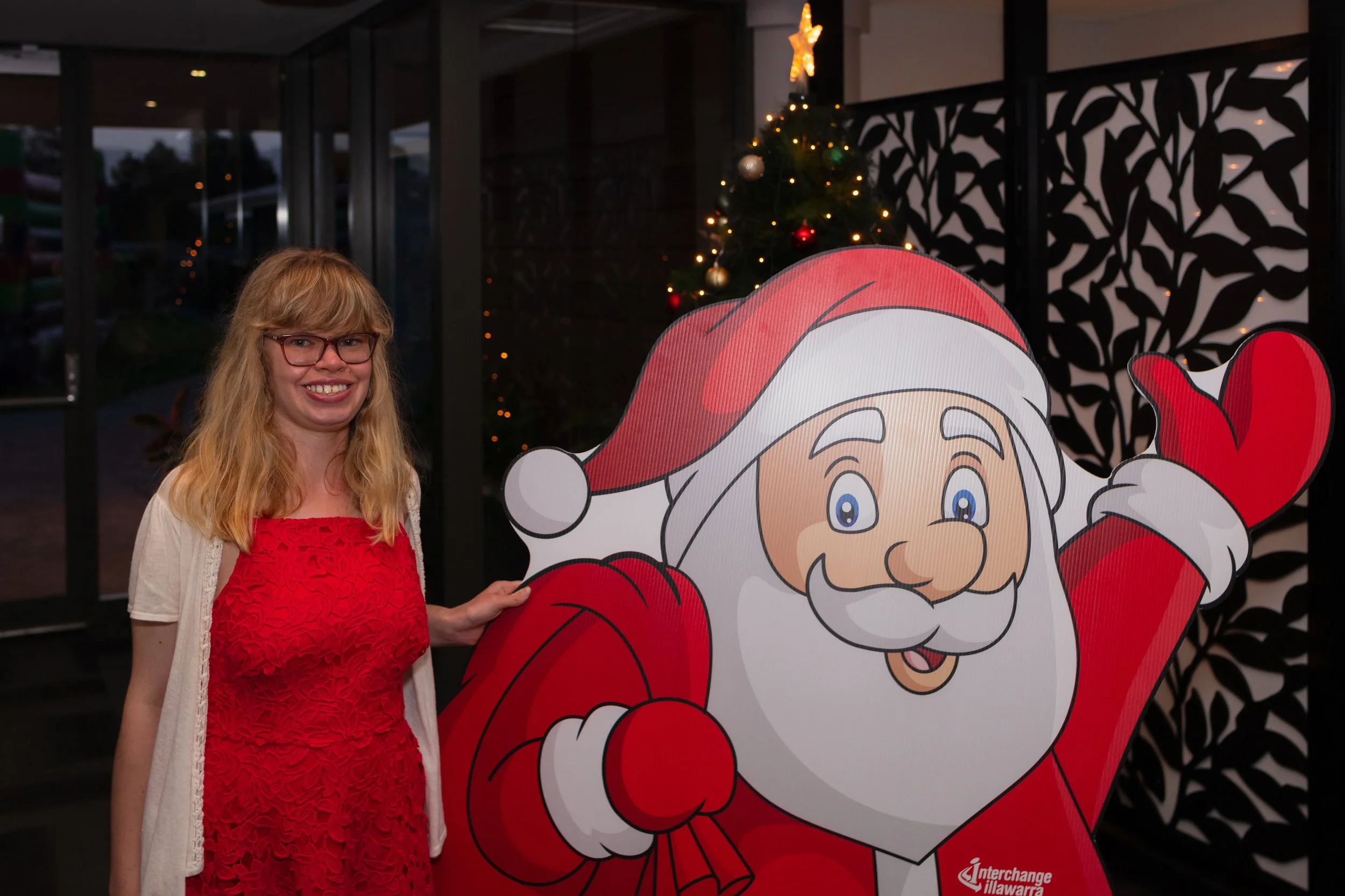 A female participant with a giant santa cut out figure