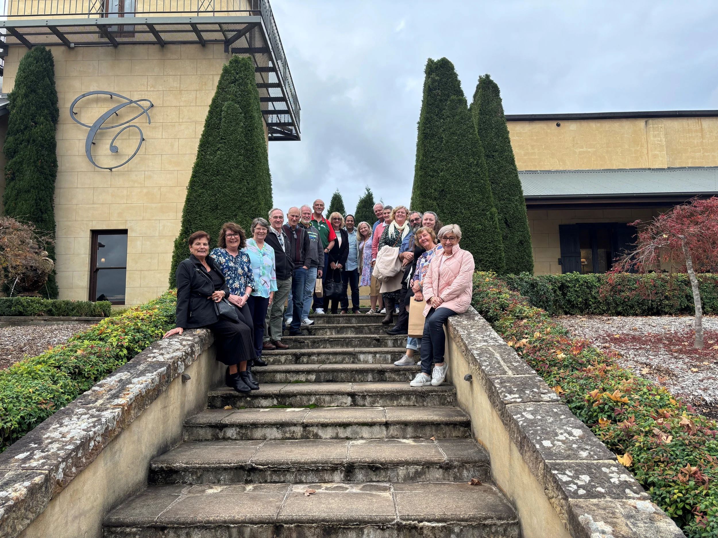 A group of parents and carers pose on the stairs of Centennial Vineyards