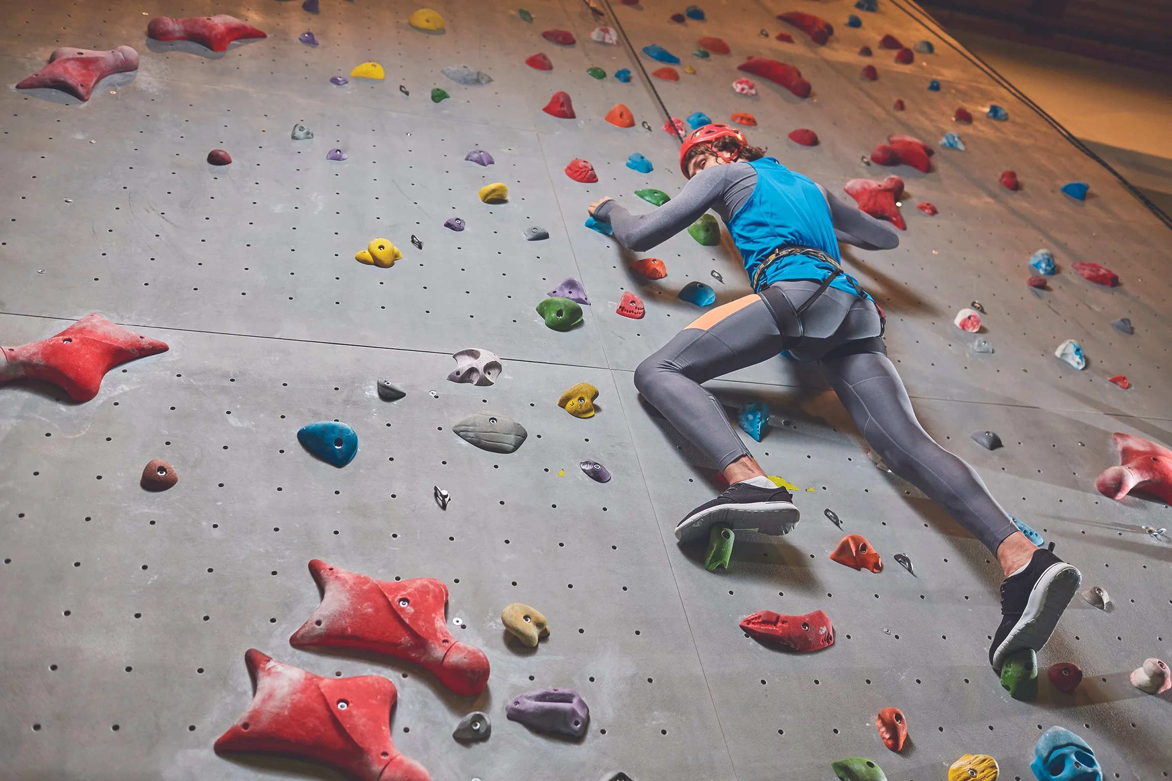 Young adult male doing indoor rock climbing