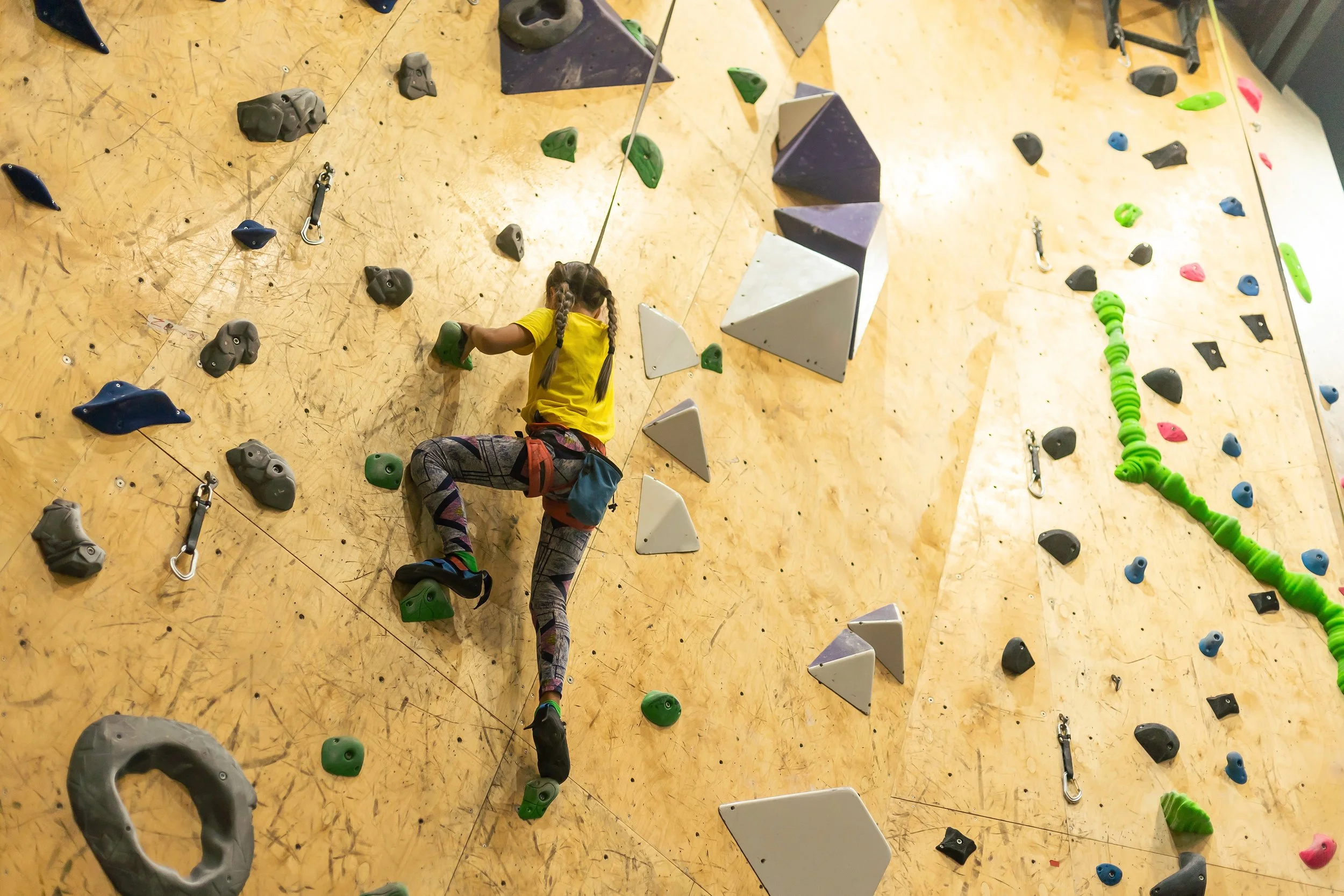 Young girl on an indoor rock climbing wall