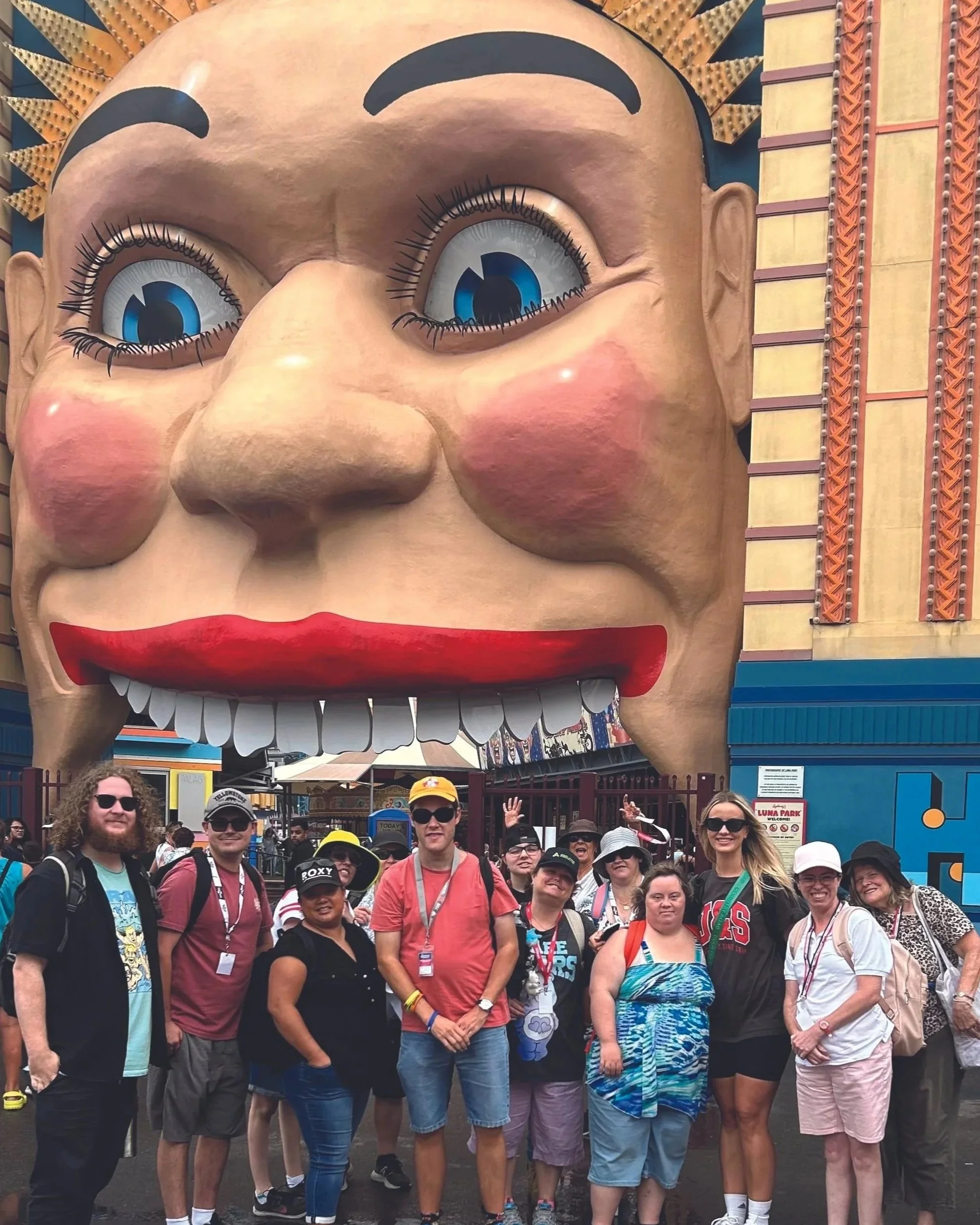 Group of participants and Support Workers out the front of Luna Park in Sydney