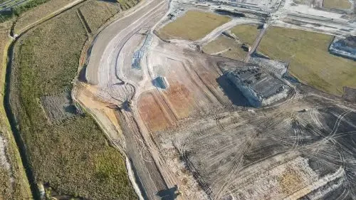 Aerial image of road construction and bulk earthworks for a new residential development with prepared building pads.