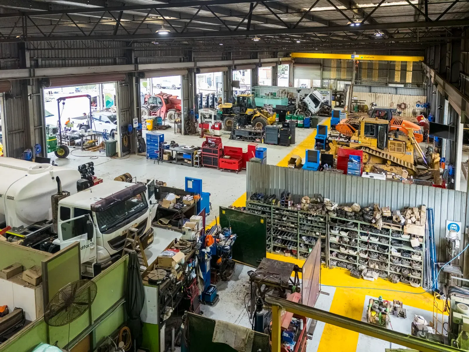 Large civil construction workshop with trucks and toolboxes.