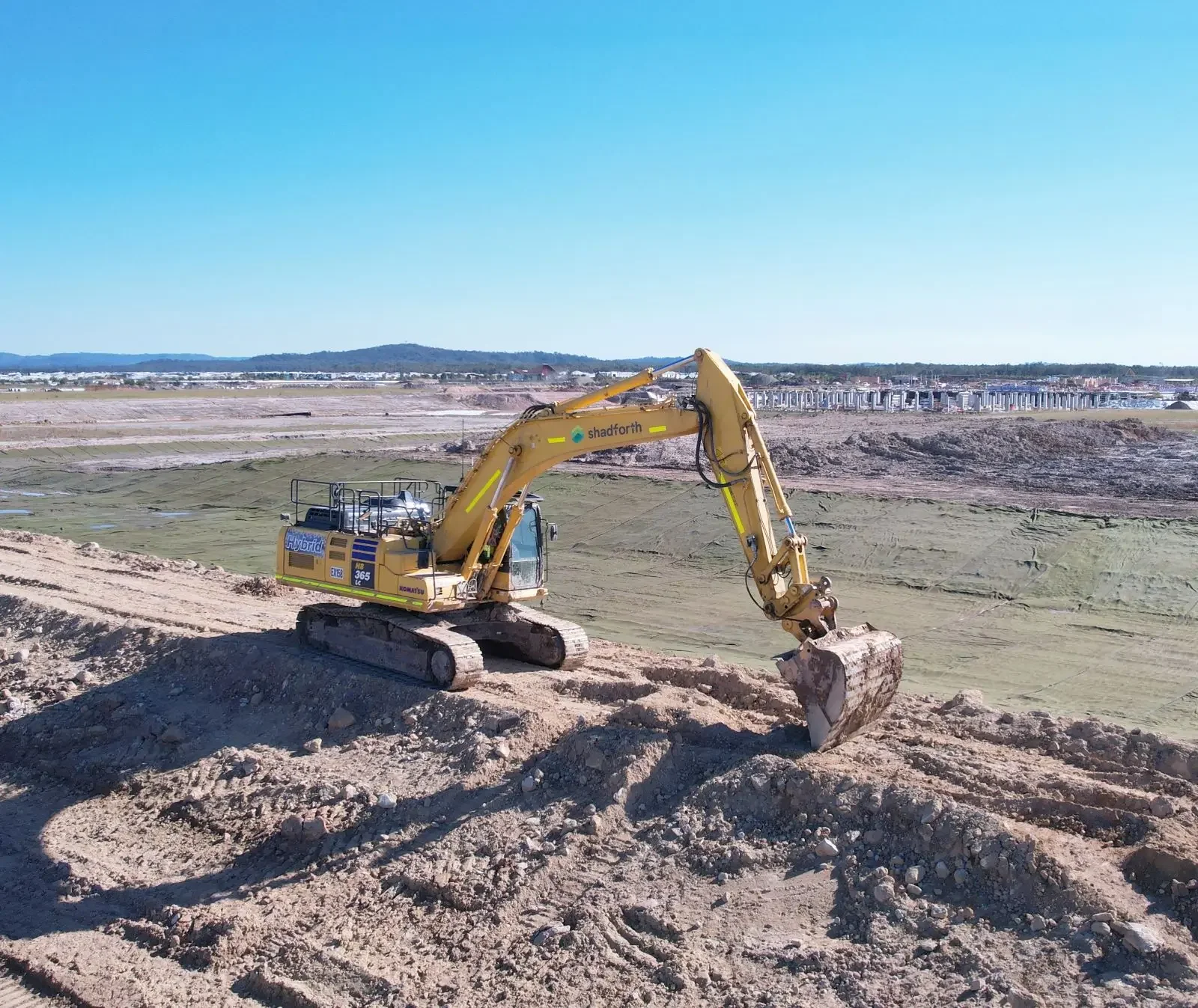 Shadforth excavator undertaking bulk earthworks on a large civil construction site, preparing land for future residential development at Aura.