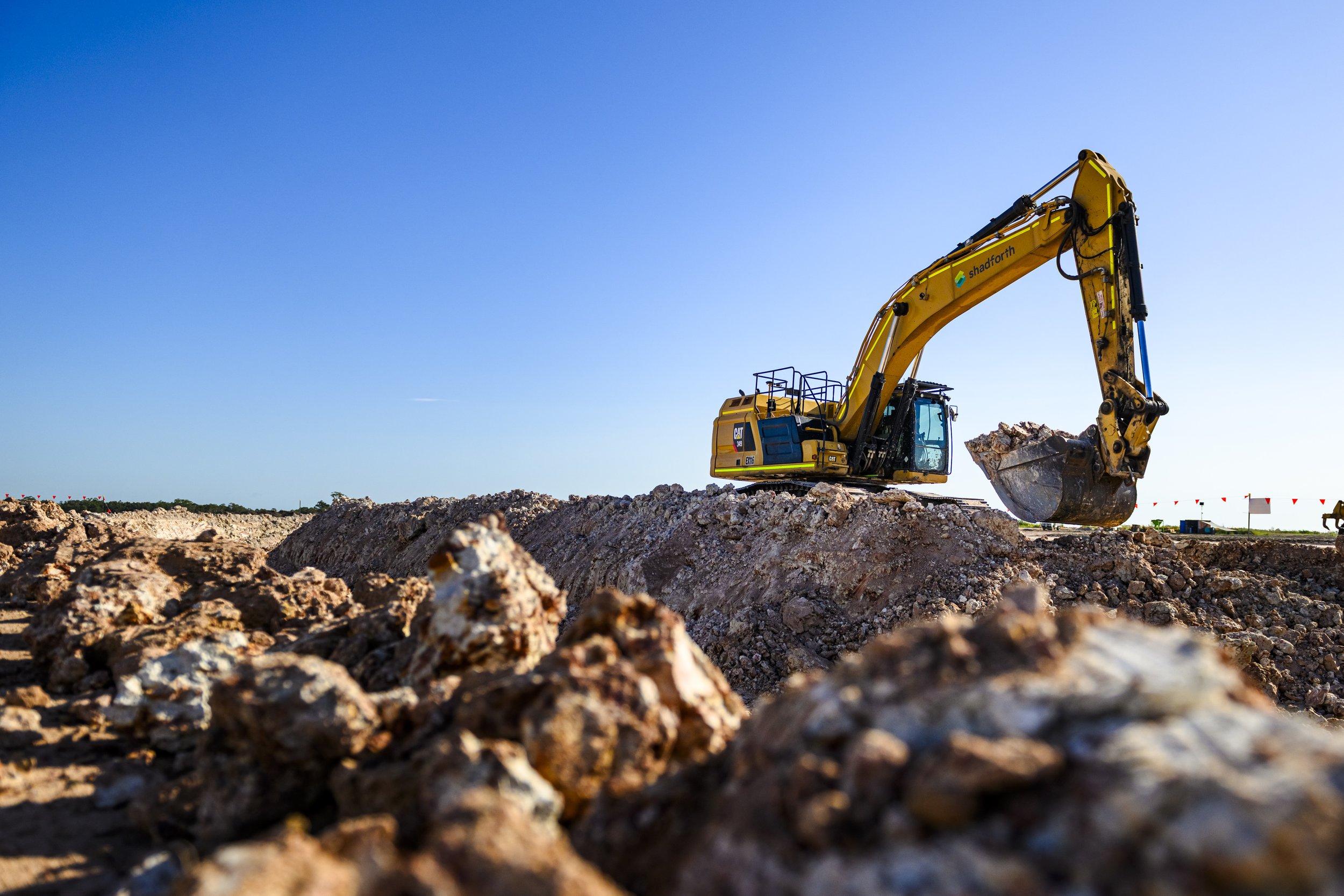 A excavator digging a trench during daytime at Aura.