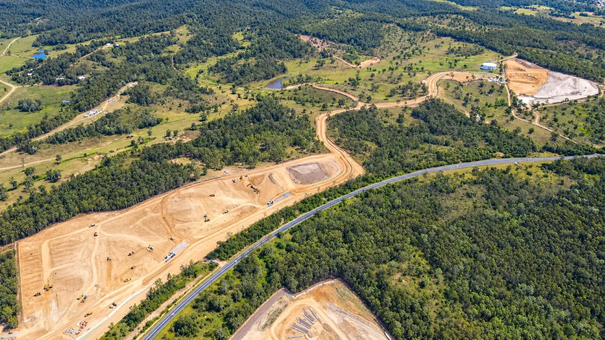 Aerial view of large-scale earthworks, road construction and surrounding bushland at Shadforth's Providence West development.