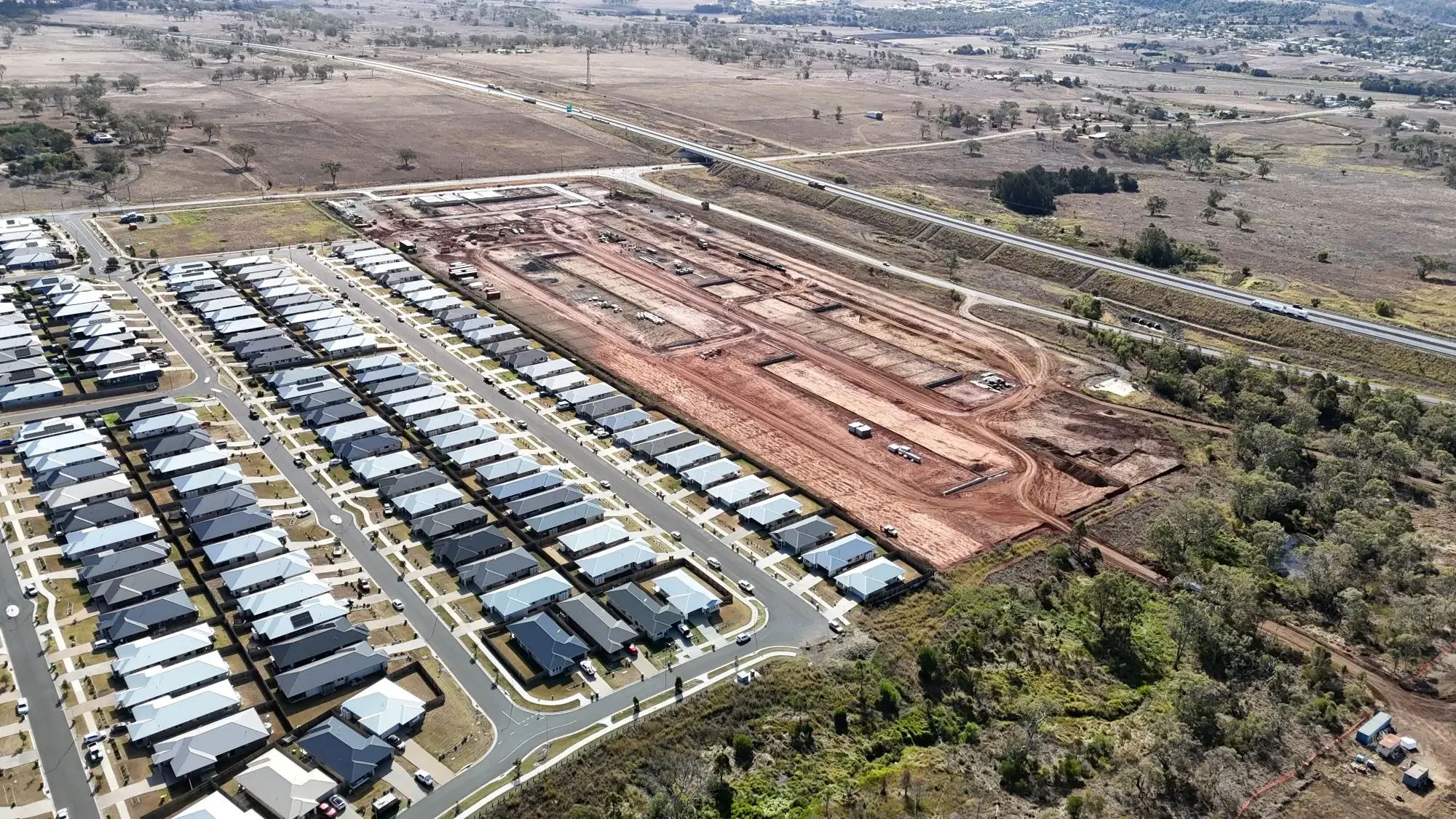 Drone view of civil construction works expanding a residential development with new roads and building lots.