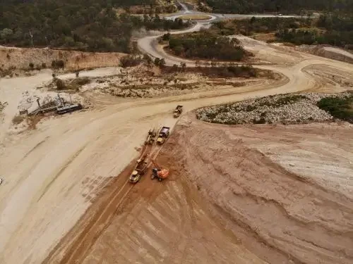 Aerial view of a construction site with trucks and machinery.
