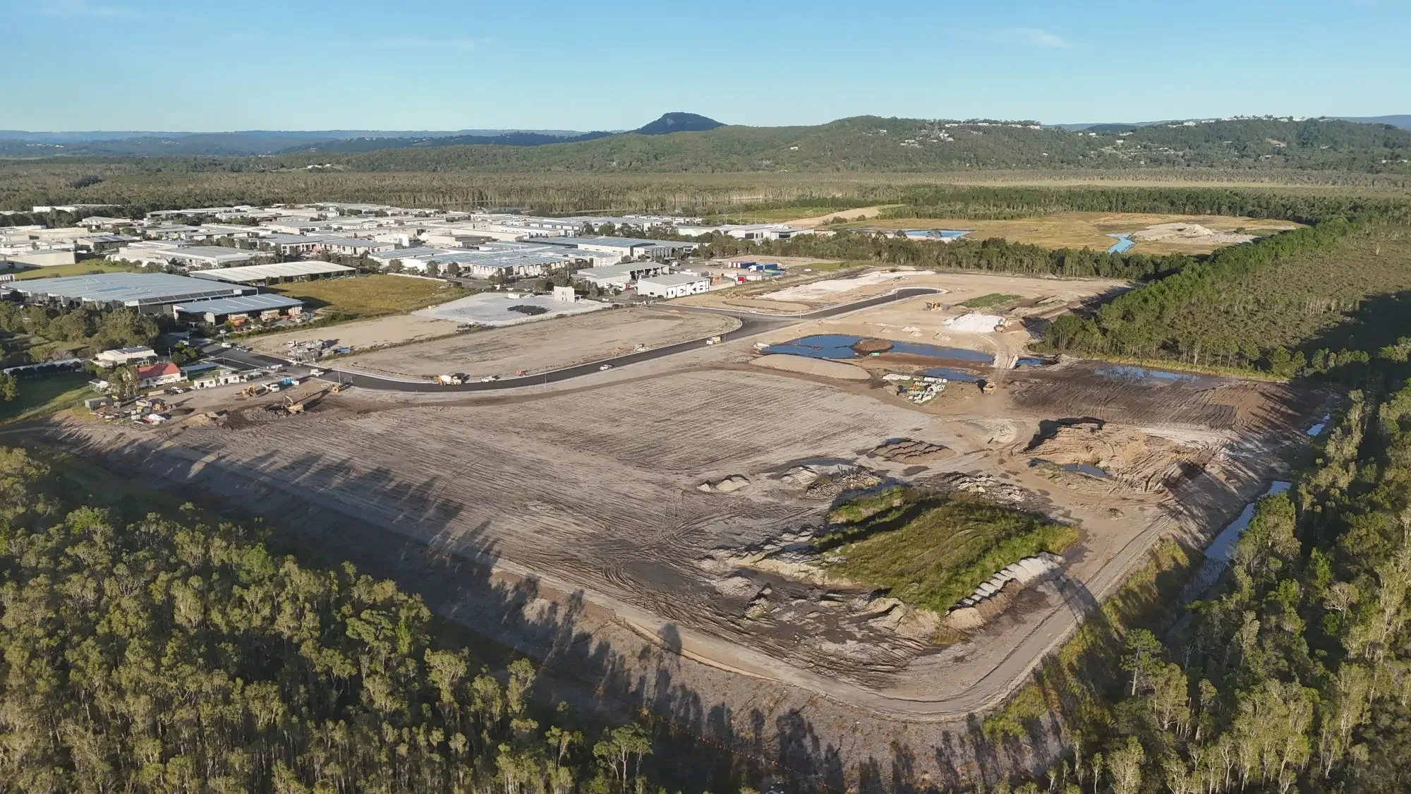 Aerial view of industrial land development with roadworks, earthworks and civil infrastructure under construction.