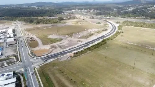 An aerial view of road and intersection with surrounding open land and fields.