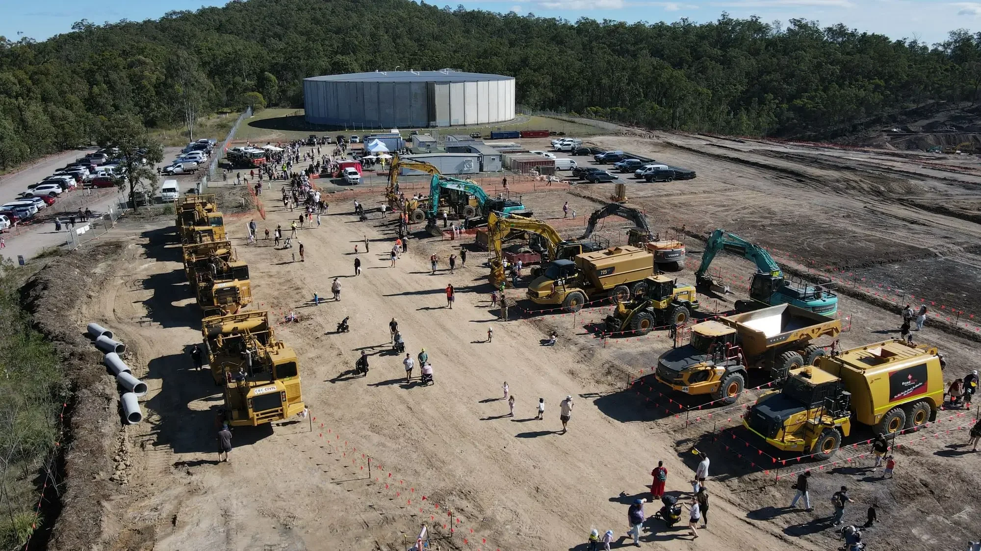 Families exploring construction machinery during a community open day at Stockland Aura construction site.