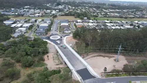 Aerial view of Ellendale Bridge construction. Trees and houses in the background.