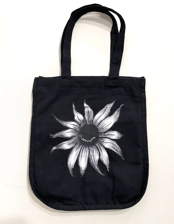 Black cotton organizer tote featuring a white smiling sunflower graphic.